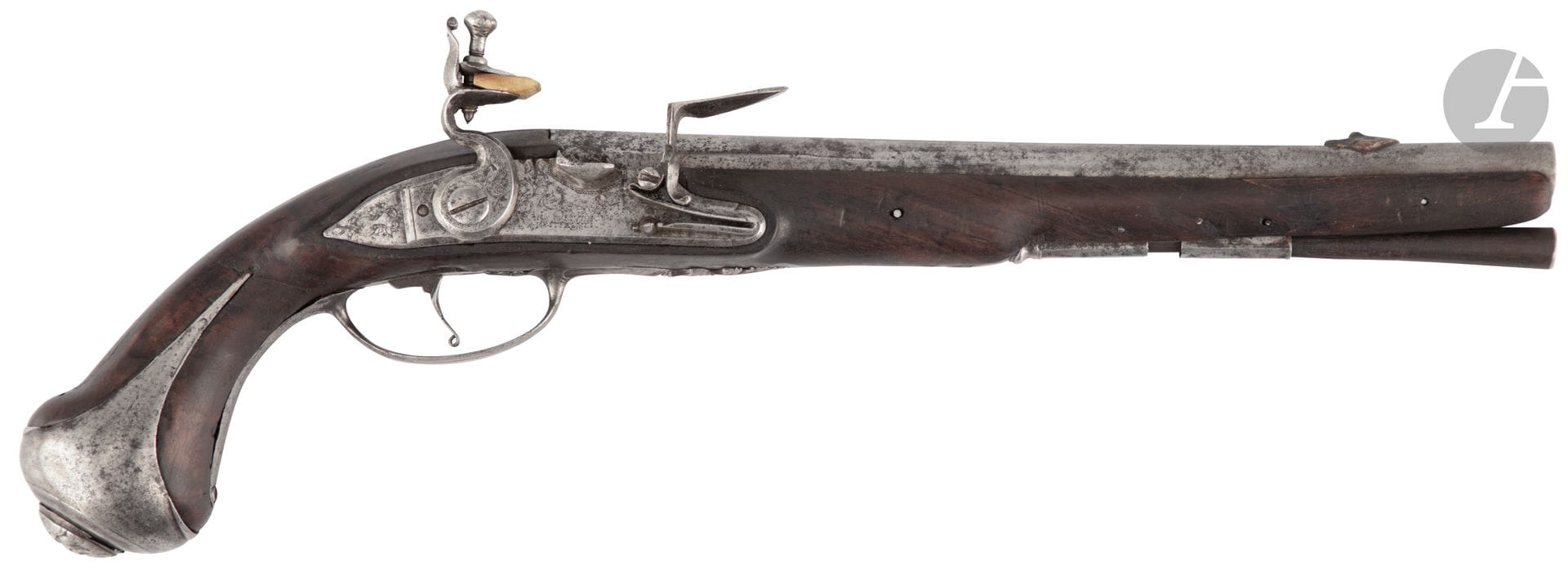 Pistolet d’arçon à silex d’officier. 
Canon rond à méplats sur le dessus, à point de mire en laiton, au masque, ciselé au tonnerre. Platine avec restes de signature et chien col de cygne à corps plats, gravés. Garnitures en fer découpé ciselé. Calotte au masque. Crosse en noyer cassée, réparée anciennement par enture. Baguette en bois.
Longueur canon : 28,5 cm - Longueur totale : 43,5 cm
Dans l’état (enture au fût, piqûres, baguette postérieure). Vers 1720 / 1740.
