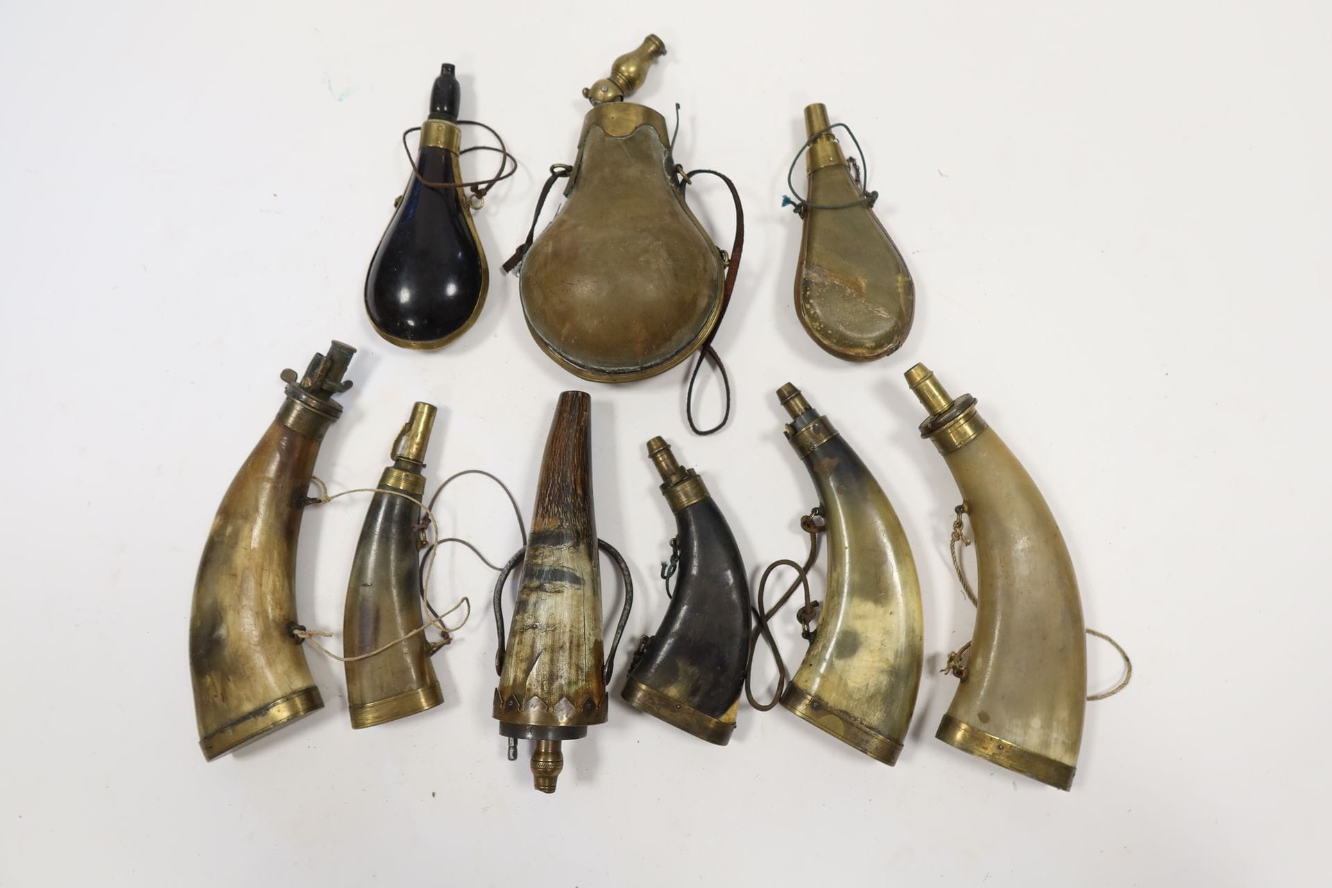 Set of nine horn powder flasks with brass fittings, some with measuring spouts.
E.M. and A.B.E.
