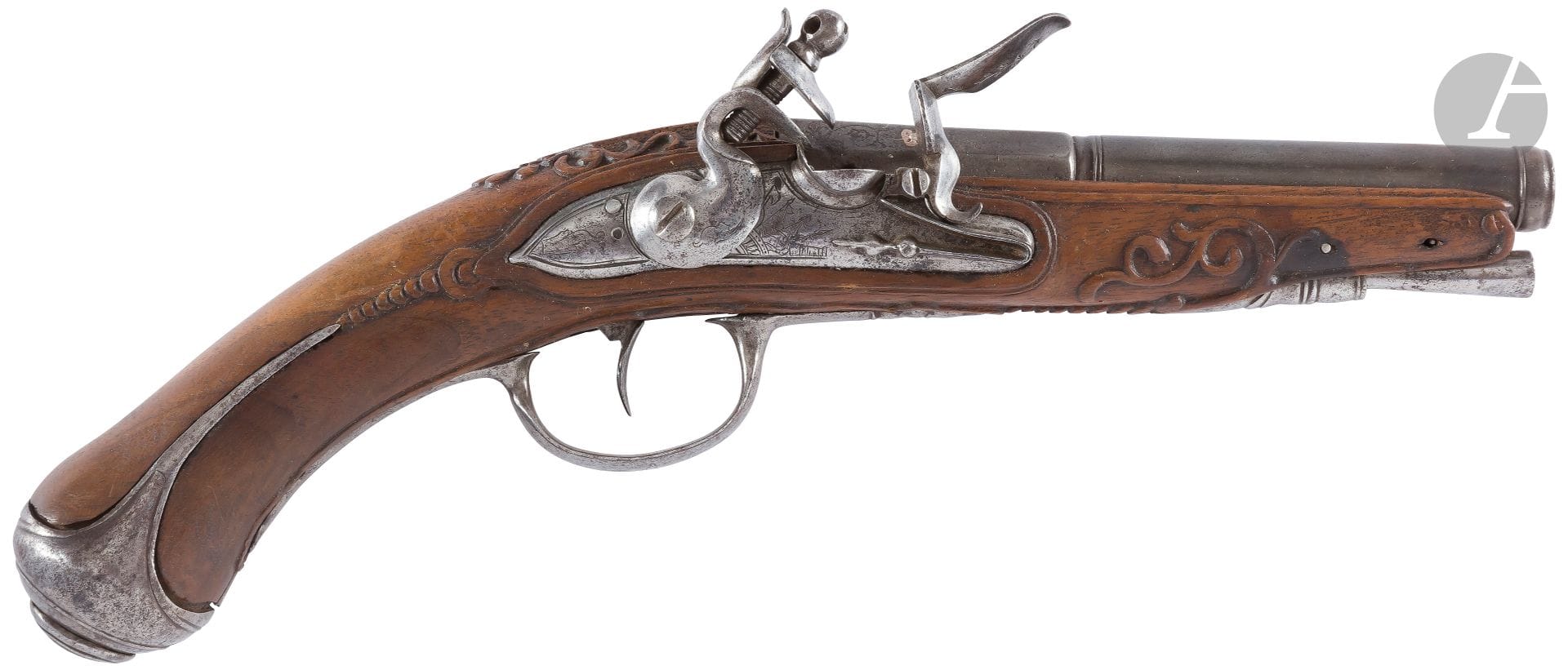 Officer's flintlock pistol. 
Round barrel, with sides to the thunder, patinated, decorated with silver inlays with decoration of foliage and crown. Lock and hammer decorated with trophies of arms and foliage, with round bodies. Chased iron fittings. Stock carved with foliage and friezes of piastres. Old iron rod mismatched. 
Length : 27 cmA
.B.E. About 1760
.

