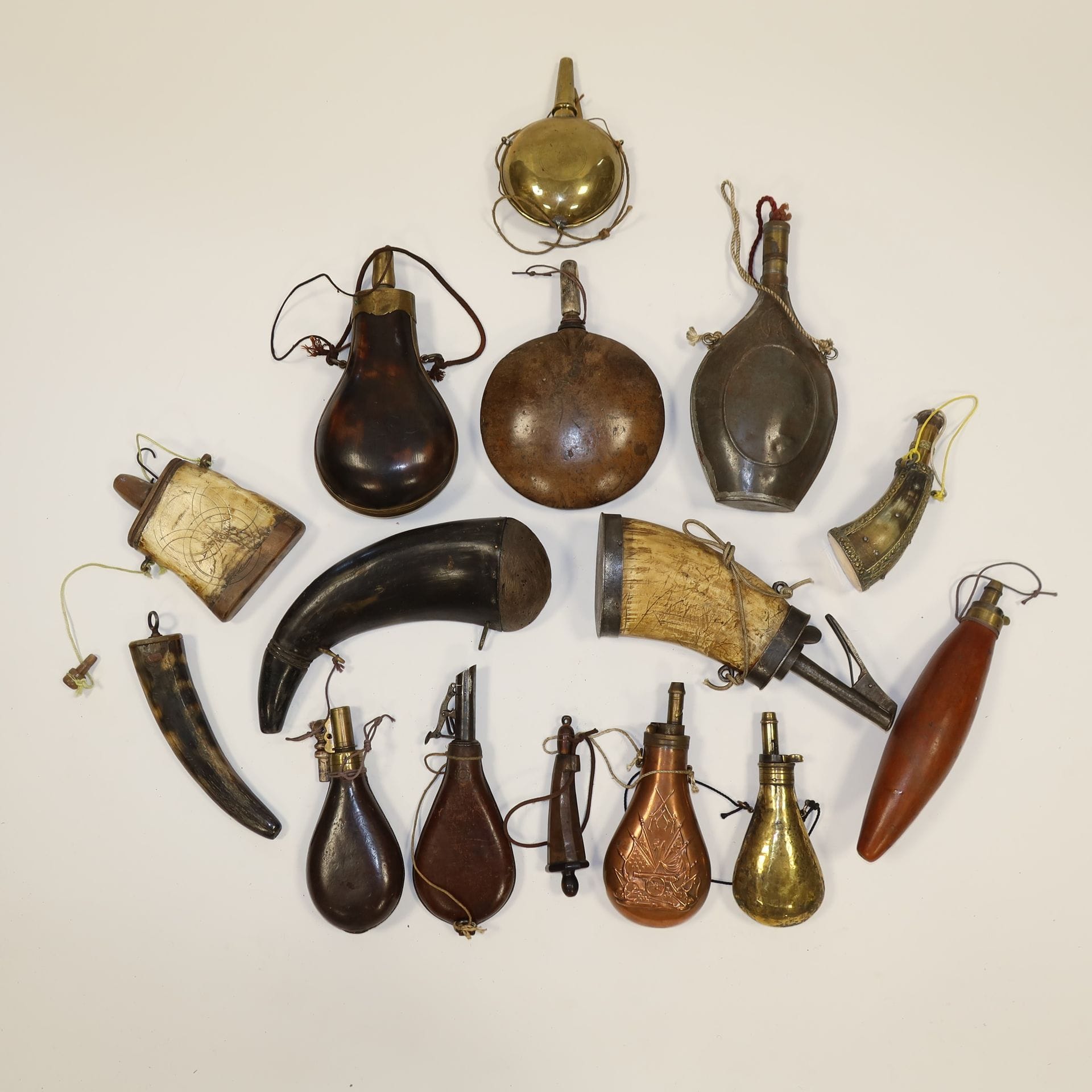 Lot of fifteen powder flasks, seven in horn, two in leather, one in sheet metal, three in copper, two in wood.
Some spouts in brass, including measuring spouts 
A.B.E
.
