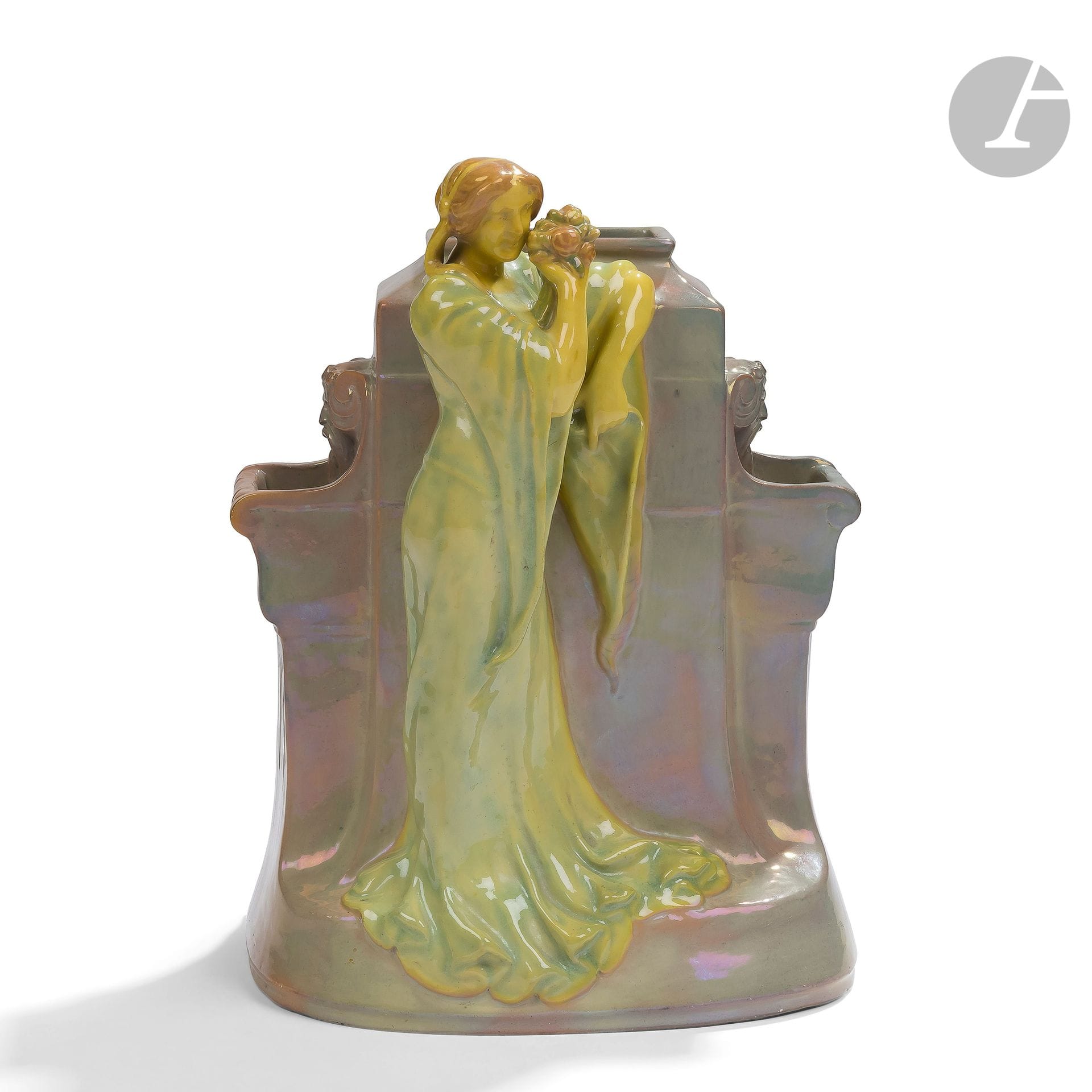 MANUFACTURE VILMOS ZSOLNAY (1828-1920)
Femme au bouquet accoudée à une fontaine
Important sujet décoratif formant bouquetière. Épreuve en céramique émaillée polychrome et aux effets d’irisation. Vers 1900. Porte le tampon rond en relief (mal apposé) et le numéro 8063 sous la base. H. 25 cm – L. 18 cm – P. 13 cm