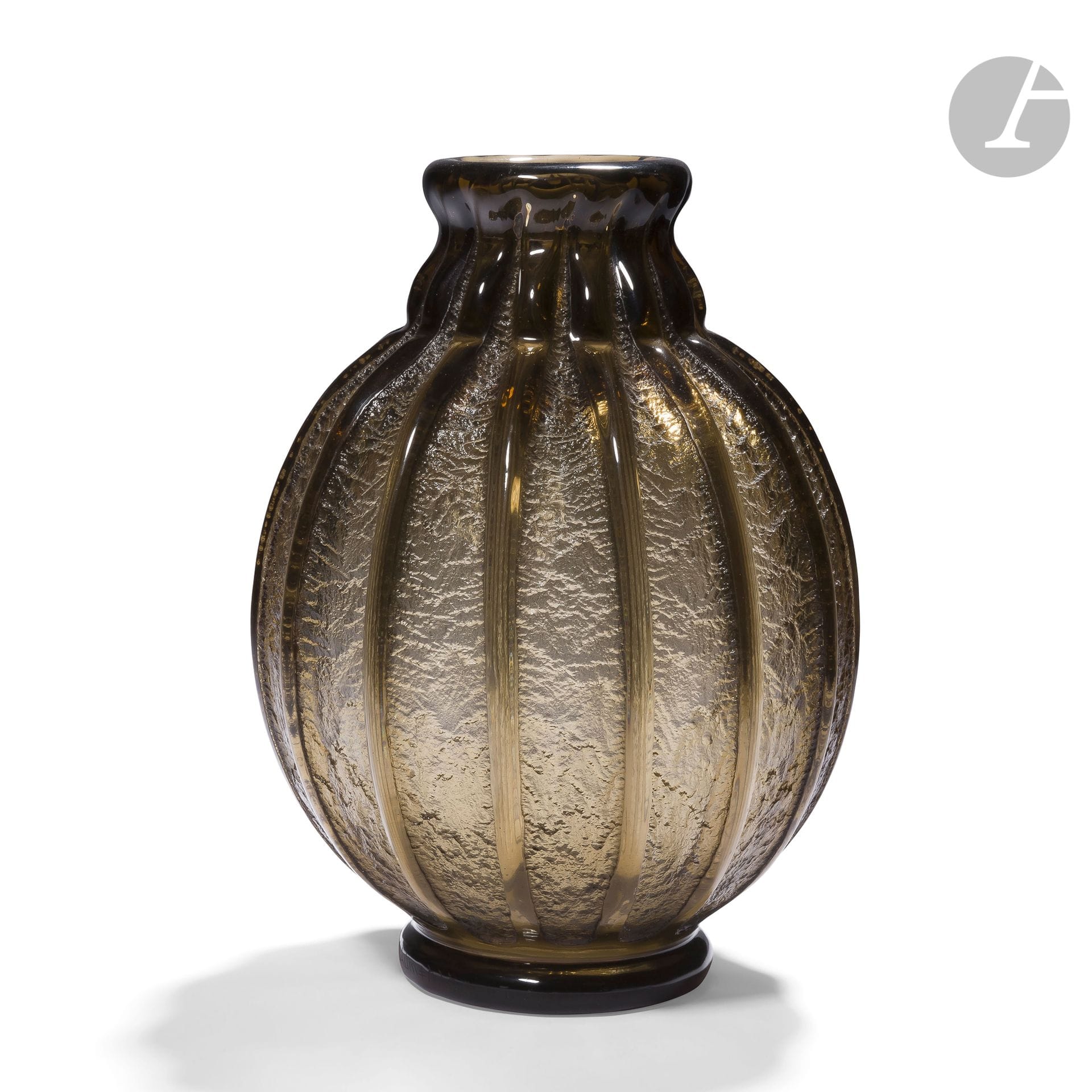 DAUM NANCY FRANCE
Vase ovoïde à côtes de melon et reposant sur talon ; le col annulaire légèrement évasé. Épreuve en verre fumé brun au décor godronné profondément dégagé à l’acide. Signé DAUM Nancy France à la Croix de Lorraine, en gravure sur le talon. H. 21,5 cm – D. 16 cm