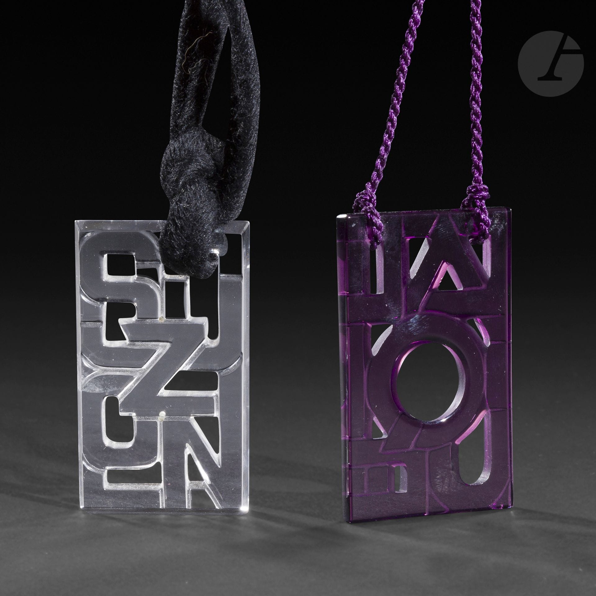 MAISON LALIQUE
Lalique & Suzon
Deux pendentifs. L’un en verre teinté mauve, l’autre en verre clair. Celui en verre mauve signé LALIQUE ® France. H. 62 cm