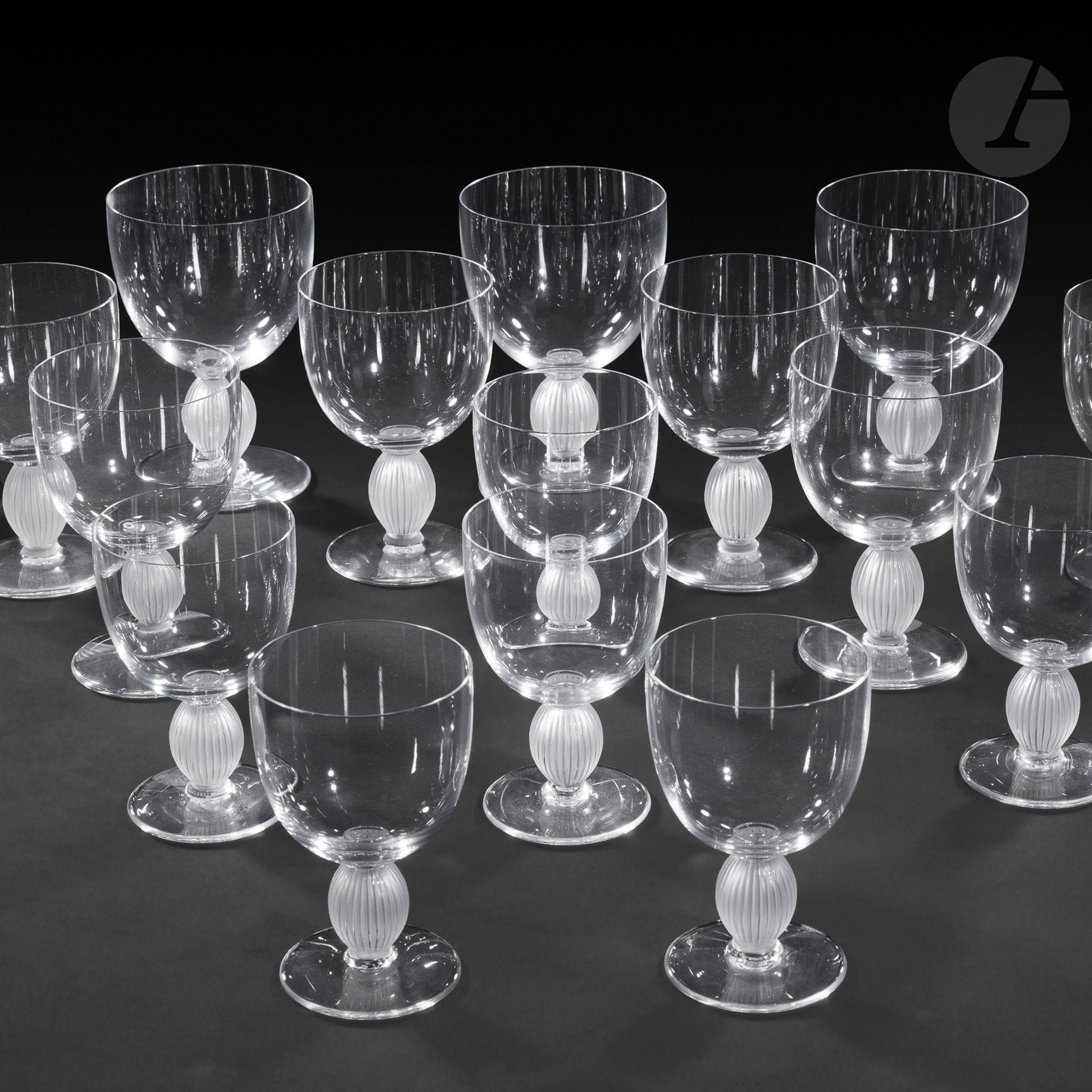 MAISON LALIQUE – MODÈLE DE MARC LALIQUE (1900-1977)
Langeais, le modèle créé en [1976]
Partie de service de verres de 18 pièces et composée de 6 verres à eau, 6 verres à vin rouge et 6 verres à vin blanc. Épreuves en cristal ; les jambes traitées en satiné. Coffrets d’origine. Chaque verre marqué LALIQUE ® France, à la pointe sous la base. H. 14,5 cm – 16 cm – 12 cm