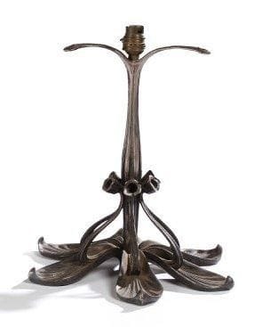 Paul FOLLOT (1877-1941) pour LA MAISON MODERNE
Pied de lampe en bronze argenté. La base, constituée de six feuilles, se poursuit par des fleurs, et reçoit un fût renflé et cannelé s'achevant par trois supports pour un abat-jour. Circa 1902/03. Hauteur: 30 cm
