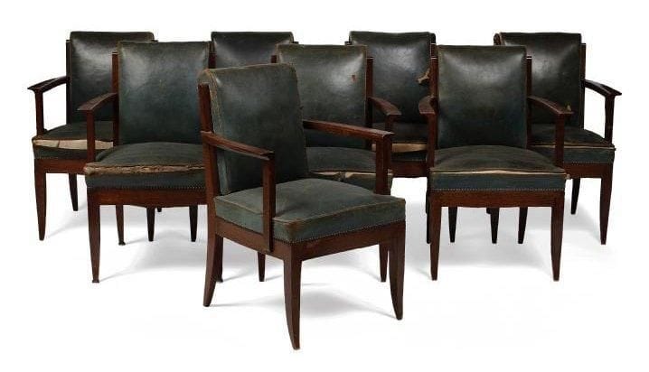 Léon JALLOT (1867-1974) & Maurice JALLOT (1900-1971)
Rare suite de huit fauteuils de table en chêne teinté et très légèrement blanchi au zinc. L'assise, à large ceinture, repose sur quatre pieds sabre se poursuivant, à l'arrière, en montants de dossier. Accotoirs à manchette débordante et sculptée. Garnitures et tapisserie en cuir vert d'origine (usagées). Circa 1932/35. 82 x 55,5 x 56 cm