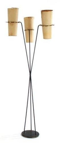 Dans le goût de Boris LACROIX
Lampadaire diabolo en métal laqué noir et laiton. Le fût en faisceau, formé de trois bras de hauteurs différentes, reçoit les éclairages bidirectionnels orientables sur rotule. Abat-jours en papier d'origine (salissures et accidents). Base circulaire formant leste. Éditions LUNEL des années 1950. Hauteur: 180 cm