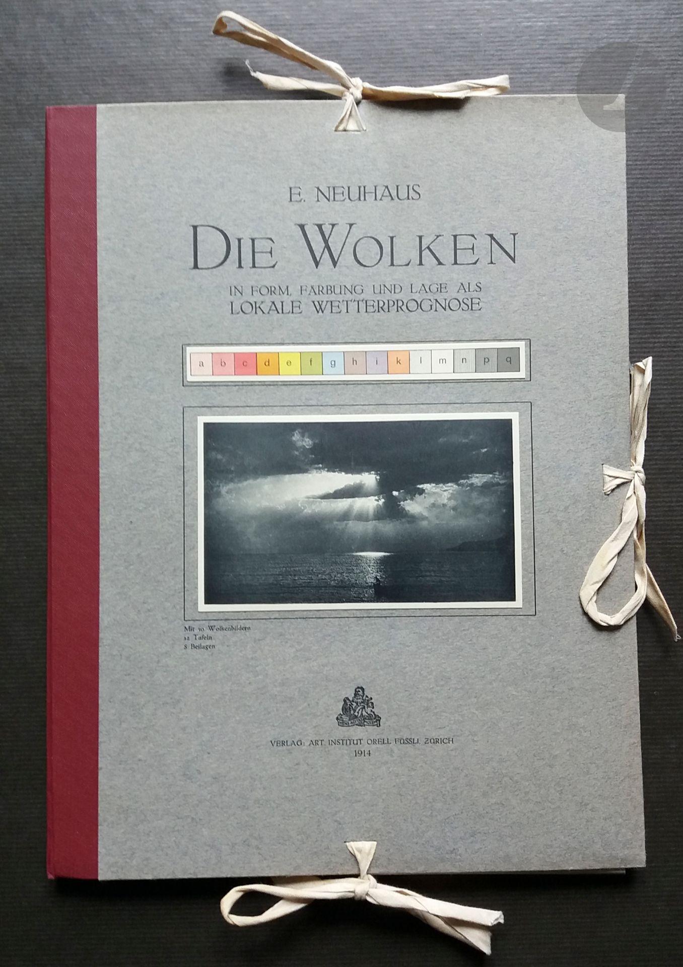 NEUHAUS, EMIL
Die Wolken
in Form, Farbung und Lage als Lokale Wetterprognose.
Verlag Art Institut Orell Fussli, Zurich, 1914.
In-4 (33 x 25 cm). Édition originale, comprenant un livret de textes en allemand de 48 pages, 16 planches reproduisant en héliogravure des vues de ciels et nuages, 18 planches de graphiques et tableaux, l'ensemble sous portefeuille à lacets titré en noir et illustrée d'une étiquette photographique.  Bien complet de l'enveloppe àen carton à trois rabats avec étiquette de titre en vert sur fond blanc.