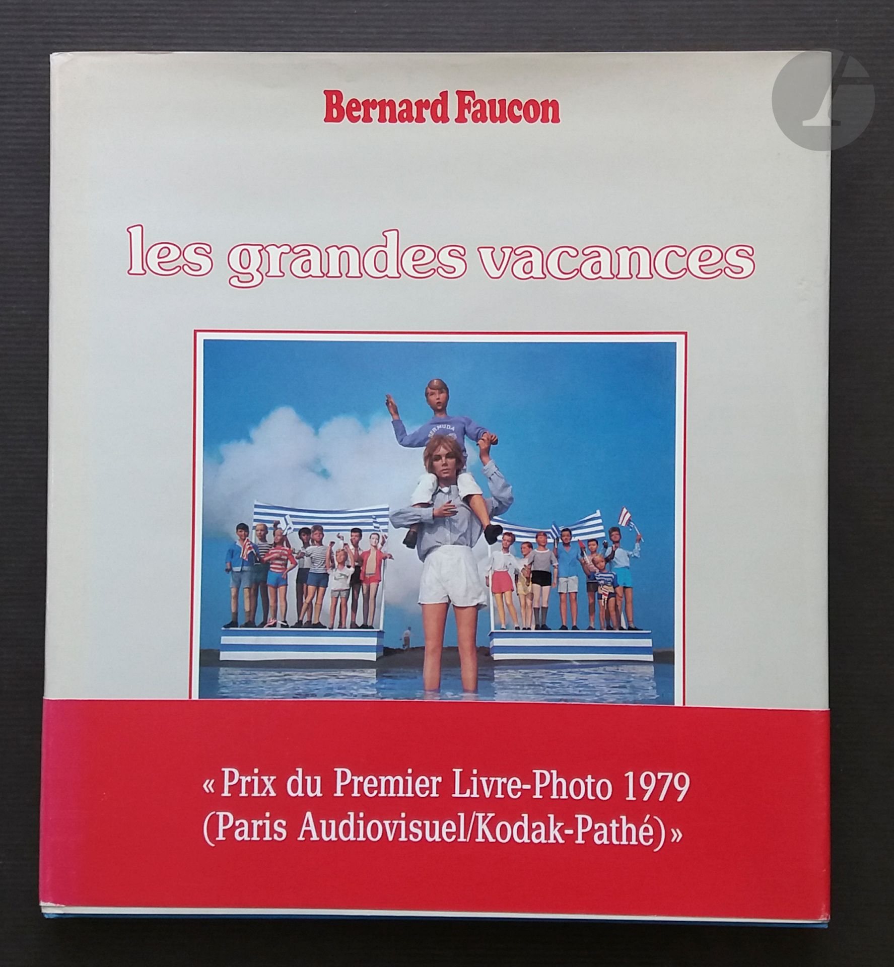FAUCON, BERNARD (1950)
Les Grandes Vacances.
Mises en scènes photographiques 1976-1980.
Herscher, 1980.
In-4 (27 x 24 cm). Édition originale. 96 pages. Cartonnage bleu d'éditeur sous jaquette illustrée et bandeau rouge du ""Prix du Premier Livre-Photo 1979"" (petite déchirure au bandeau; livre et jaquette en parfait état.