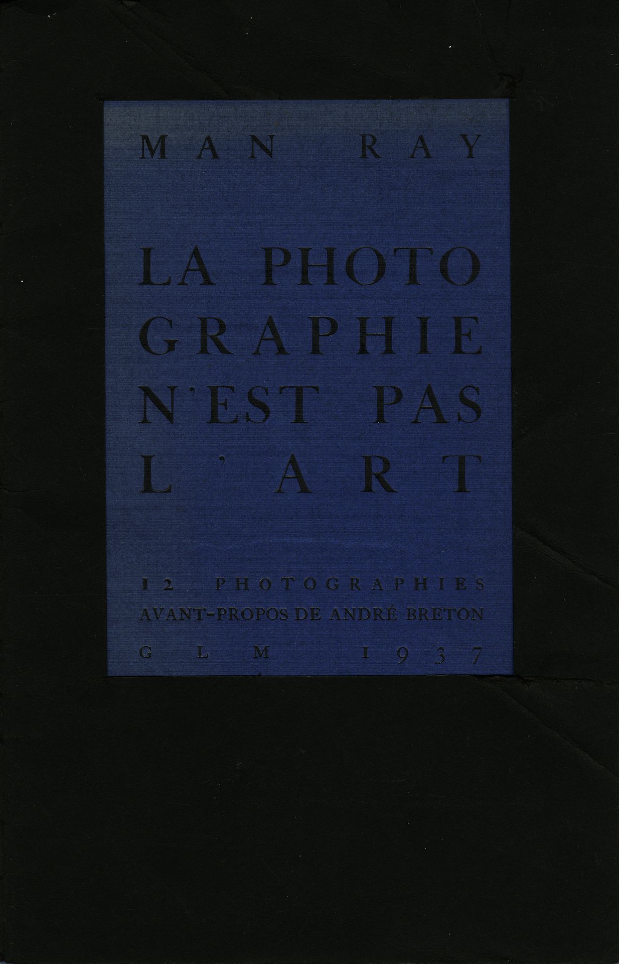 MAN RAY (1890-1976)
La photographie n'est pas l'art. 12 photographies. Avant-propos de André Breton.
GLM, 1937.
In-8 (25,5 x 16,5 cm). Édition originale, en feuilles. Jaquette noire de l'éditeur (froissée et pliée), avec forme de découpe, et couverture bleue titrée (décoloration). Une feuille de titre, une feuille de colophon, trois feuilles de texte et 12 planches de photographies reproduites en noir et blanc. Quelques rousseurs sur les planches. 
Ref. Parr & Badger I, pp. 108-109.