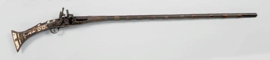 Fusil à silex d'Afrique du Nord dit Moukalah. Canon rond à garnitures en cuivre. Platine à la Chenapan. Crosse à incrustations d'os. A.B.E. XIXe siècle