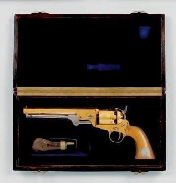 Revolver commémoratif Golden Rebel, au modèle de Colt Navy 1851, Calibre 36, six coups. Canon à pans. Barillet gravé de scènes navales. Crosse en noyer avec pièce numérotée n°298. Avec moule à balles, poire à poudre estampée à l'Aigle, balles et amorces. T.B.E. Dans son coffret gainé de velours bleu