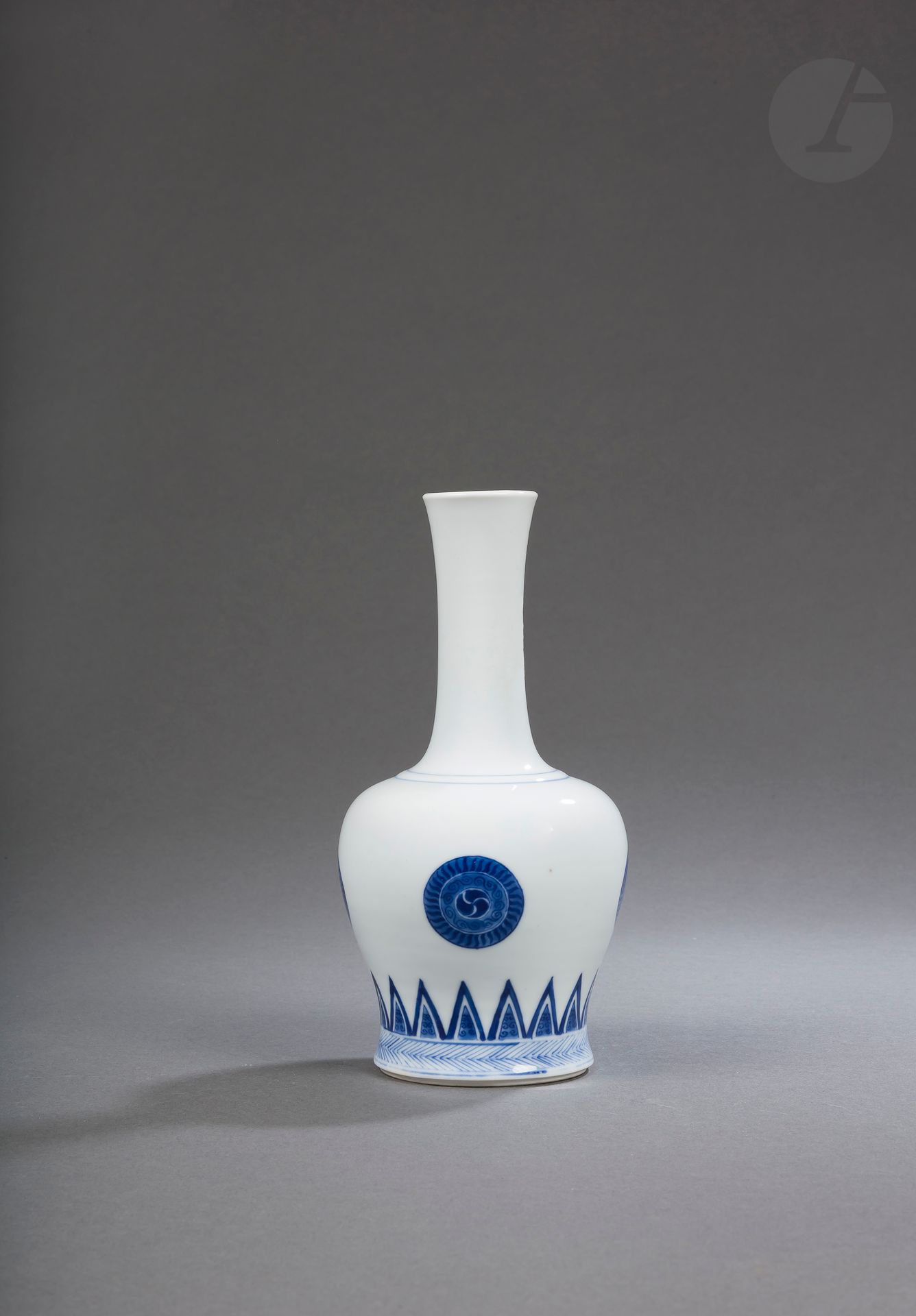 Rare white porcelain yaoling zun vase glazed in blue underglaze, China, mark and probably of the Kangxi period (1662-1722)
The body, surmounted by a high, slightly flared neck, is decorated with four medallions in the form of archaic mirrors above a band of triangular escutcheons enclosing ruyi heads and emerging from a frieze of fine chevrons. Kangxi mark with six characters in kaishu within a double blue circle at the base.
Traces of collection labels on the neck.
Height : 20 cm
Small firing defect on the body.

Provenance: 
Spink &amp; Son Ltd. label.

清 可能康熙- 青花团花纹摇铃尊
款：大清康熙年制

Paris private collection - lots 78 to 127, 219 and 220