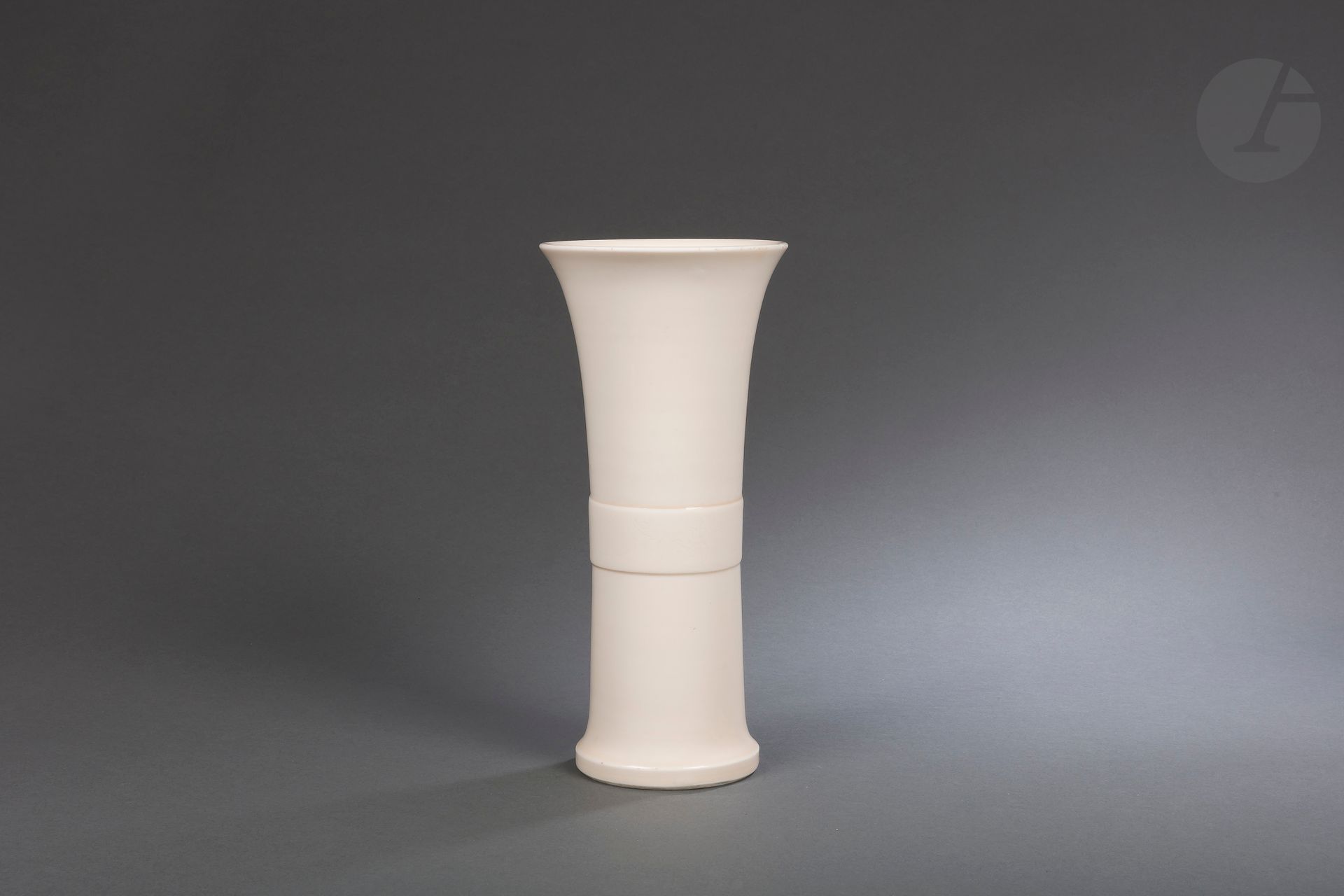 Grand vase gu en porcelaine Blanc de Chine, Dehua, Chine, époque Kangxi (1662-1722)
De forme inspirée des bronzes archaïques, la partie médiane est entourée d’un bandeau en léger relief à décor incisé de fleurs et feuilles de lotus. Le col est évasé. Belle couverte de couleur ivoire.
Hauteur : 33 cm
Trace d’étiquette sous la base.

清 康熙 - 德化窑白釉划花大花觚

Collection particulière parisienne - lots de 78 à 127, 219 et 220