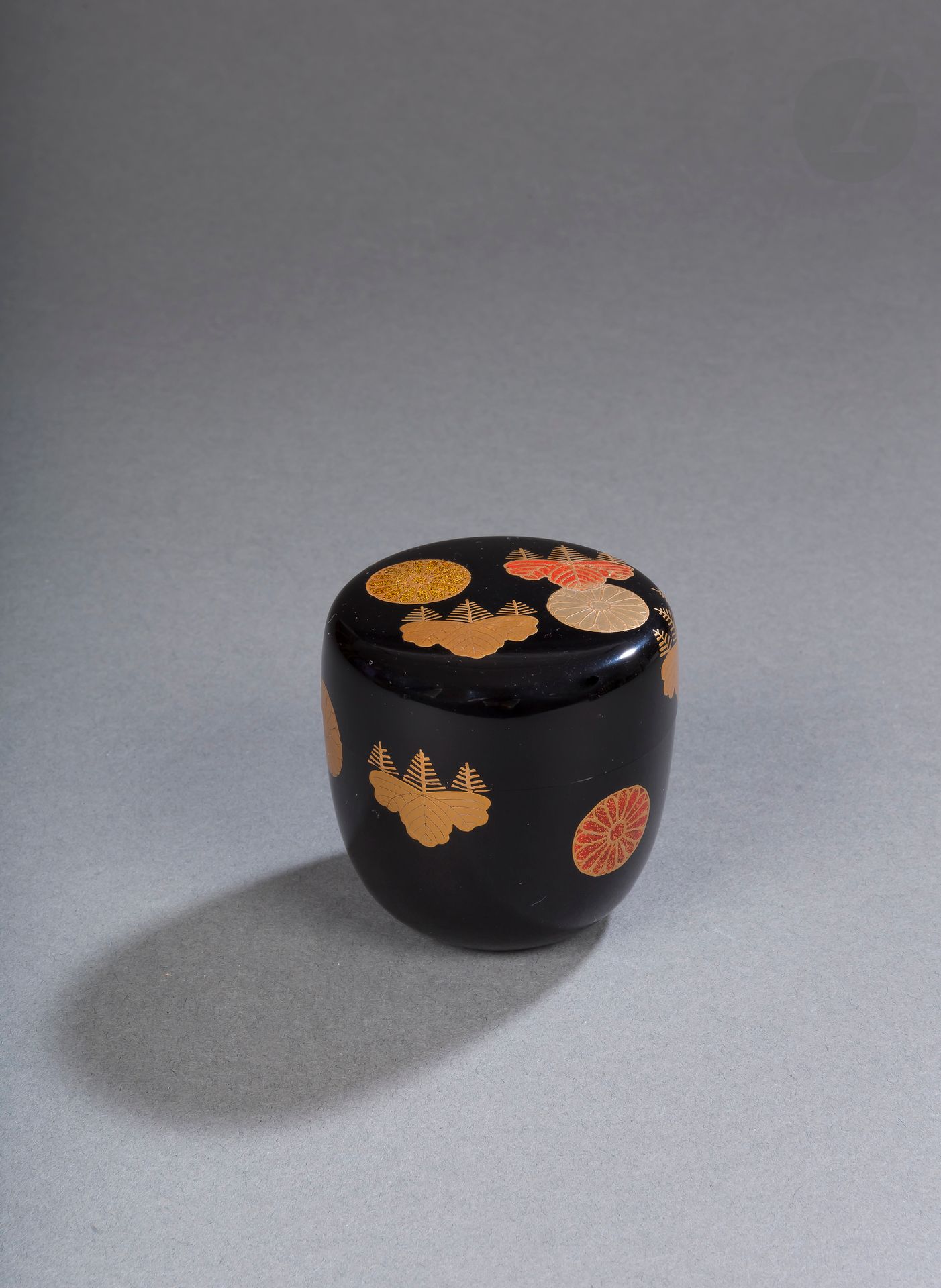Natsume, boîte à thé en poudre, Japon, époque Meiji-Taisho
En bois et laque kodaiji maki-e à décor en hiramaki-e de mon symbolisant la famille impériale. Le kiku mon (en forme de chrysanthème) à seize pétales et le kiri mon (en forme de fleur de paulownia). Dans une boîte de protection en kiri portant sur le côté l’inscription : 高台寺蒔絵 大棗 塗師宗哲 - Kôdaijimakie Ô natsume nurishi Sôtetsu - « Grand natsume en kôdaiji makie par le laqueur Sôtetsu », suivie d’un sceau. A l’intérieur du couvercle l’inscription : 宗哲作 高台寺蒔絵 大棗 宗哲 大棗 - Sôtetsu Saku Kôdaijimakie Ô natsume - « Grand natsume en kôdaiji makie fait par Sôtetsu ».
Marque à la pointe sèche et kao en laque rouge.
Hauteur : 6,9 cm

Collection particulière parisienne - lots de 78 à 127, 219 et 220