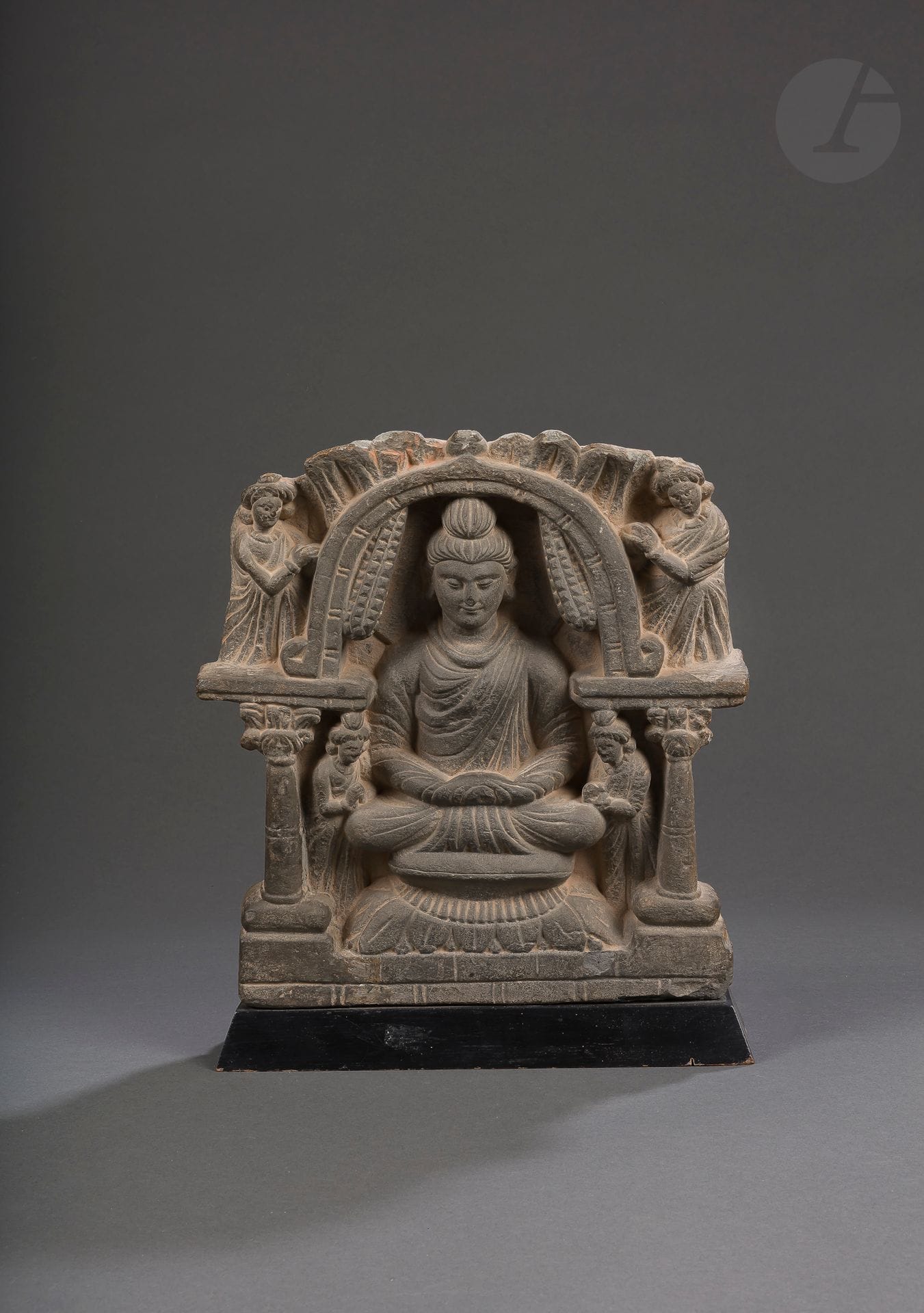 Grey schist Buddha, Pakistan, ancient Gandhara region, 3rd - 4th century
The Buddha, seated on a lotus base, is inscribed in a niche supported by columns. Four orants or bodhisattvas pay homage to him, two standing at his feet and the other two, outside the niche, at shoulder level. The Buddha is dressed in the pleated monastic robe characteristic of the period, his hands in his lap, in the meditation position. The face is serene, the earlobes elongated, the eyes half-closed, the hair pulled back in a bun on the top of the skull forming a cranial protuberance.
Height : 28 cm
Erosions, accidents, missing parts, restoration.
 
Provenance: 
- 1983-2023, Paris collection.
- Briest sale, February 17, 1983, lot 92C (Expert Portier).

