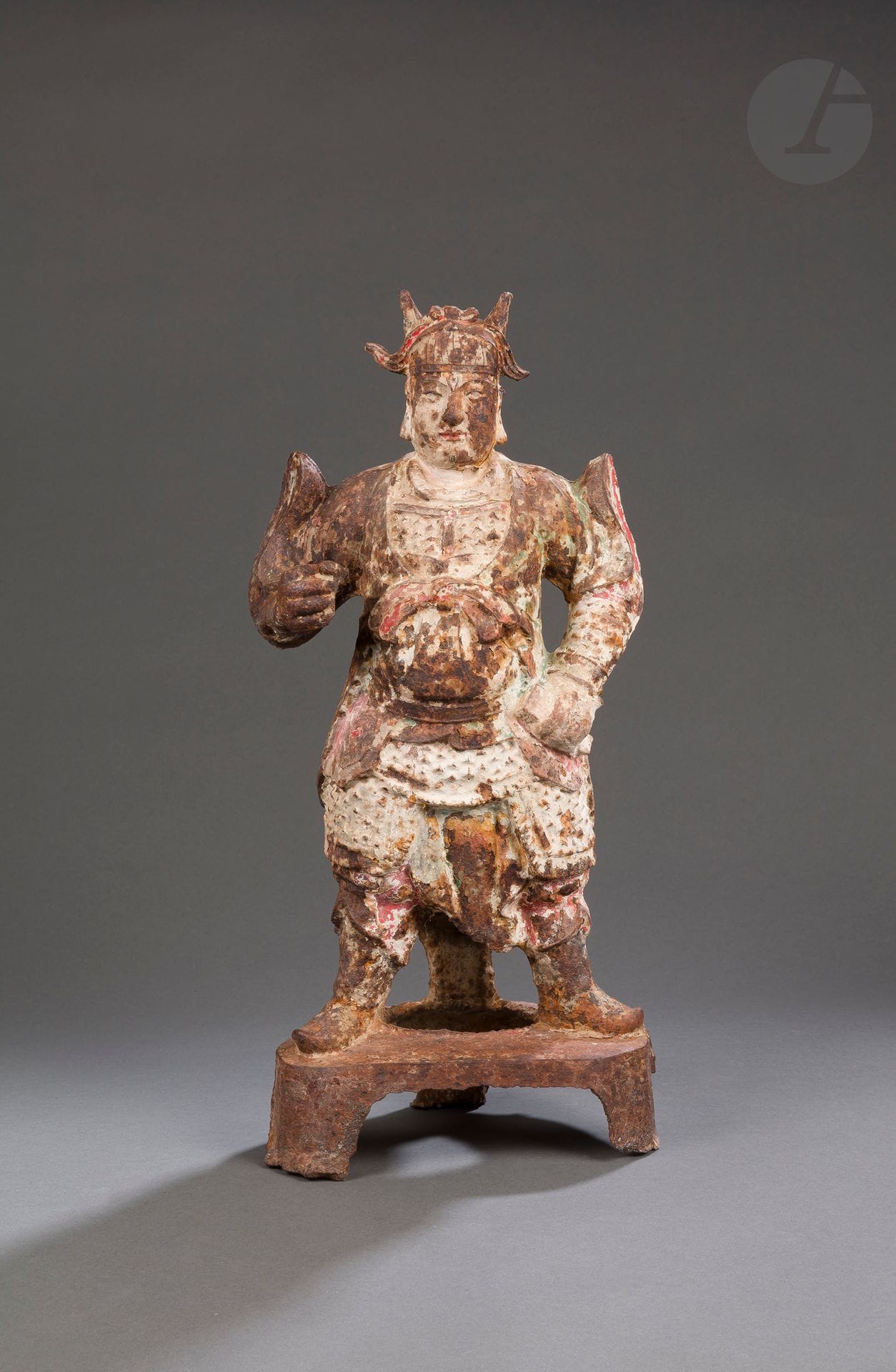 Cast iron lokapala, China, late Ming period, 17th century
Depicted standing on a tripod base, wearing an imposing armor and a helmet, the left hand resting on the hip holding an attribute while the right hand is clasped around a spear, which has now disappeared. Remains of polychromy on the whole figure and black pigment drawing a beard and a mustache.
Height : 56 cm

十七世纪 晚明 - 铸铁天王像

