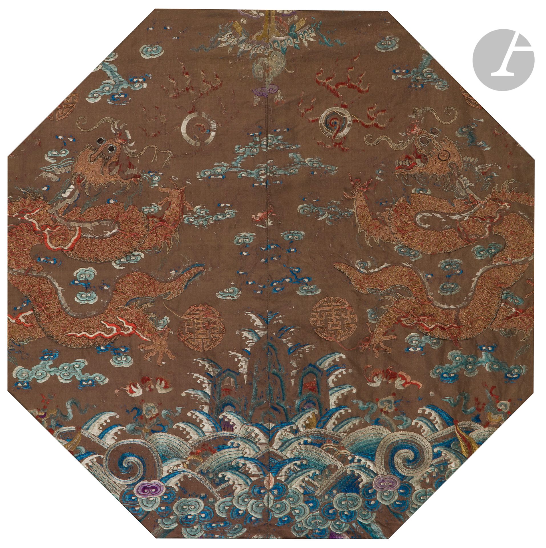 Deux fragments de robe brodés en soie bleue et fils d’or sur fond beige de dragons, Chine, fin du XIXe siècle
Les deux morceaux, provenant probablement du bas d’une robe de mandarin, sont à décor de vagues de l’Océan d’où émergent les rochers de la Terre encadrés par deux dragons à cinq griffes dans les nuages à la poursuite de perles enflammées
49,5 x 49,5 cm à vue
Encadrés sous verre. Usures et manques.

十九世纪晚期 - 牙白地金蓝线绣云龙海水江崖纹丝裙局部两片

