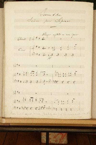 Alfred BRUNEAU (1857-1934)
Manuscrit musical autographe, Jeanne d'Arc, Scène pour soprano, [op. 2, 1878] ; titre et 18 pages in-fol.Scène lyrique, une des premières compositions d'Alfred Bruneau. Cette Jeanne d'Arc, « Scène pour Soprano », sur un poème d'Alfred de Musset, fut composée par le jeune Bruneau après avoir remporté le premier prix de violoncelle au Conservatoire en 1876, et avant d'entrer, en décembre 1879, dans la classe de composition de Jules Massenet. Le poème d'Alfred de Musset : « Je cherche en vain le repos qui me fuit »... avait été écrit en vue d'une cantate pour Pauline Viardot ; il fut publié après la mort du poète, et recueilli en 1860 dans les oeuvres posthumes. Cette scène, pour chant et piano, en ré majeur, commence Allegro agitato e con fuoco, par une introduction instrumentale à 4/4, avant le Récit lentement déclamé : « Je cherche en vain le repos qui me fuit »..., puis l'Andante à 12/8 : « Sombre forêt retraite solitaire »... Le manuscrit, à l'encre brune sur papier Lard-Esnault à 12 lignes (4 systèmes de 3), présente des corrections, des mesures biffées, et 6 collettes. Il a été publié en 1878 par les éditeurs Étienne et Auguste Girod