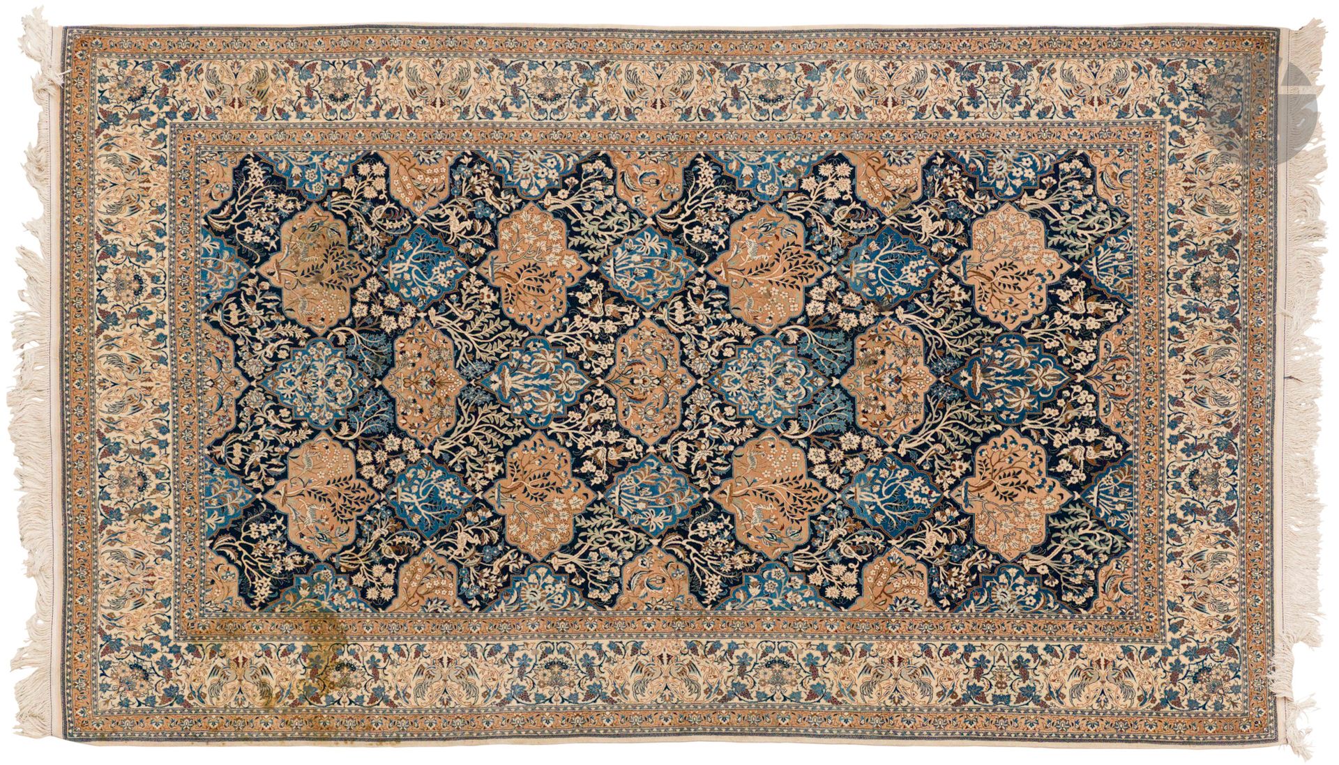 NAÏN, XXe siècle, velours laine et soie (5%), velours laine, chaînes et trames coton.
Tapis à fond bleu marine à décor de multiples réserves et d’éléments floraux, bordure ivoire à guirlandes de fleurs.
182 x 300 cm