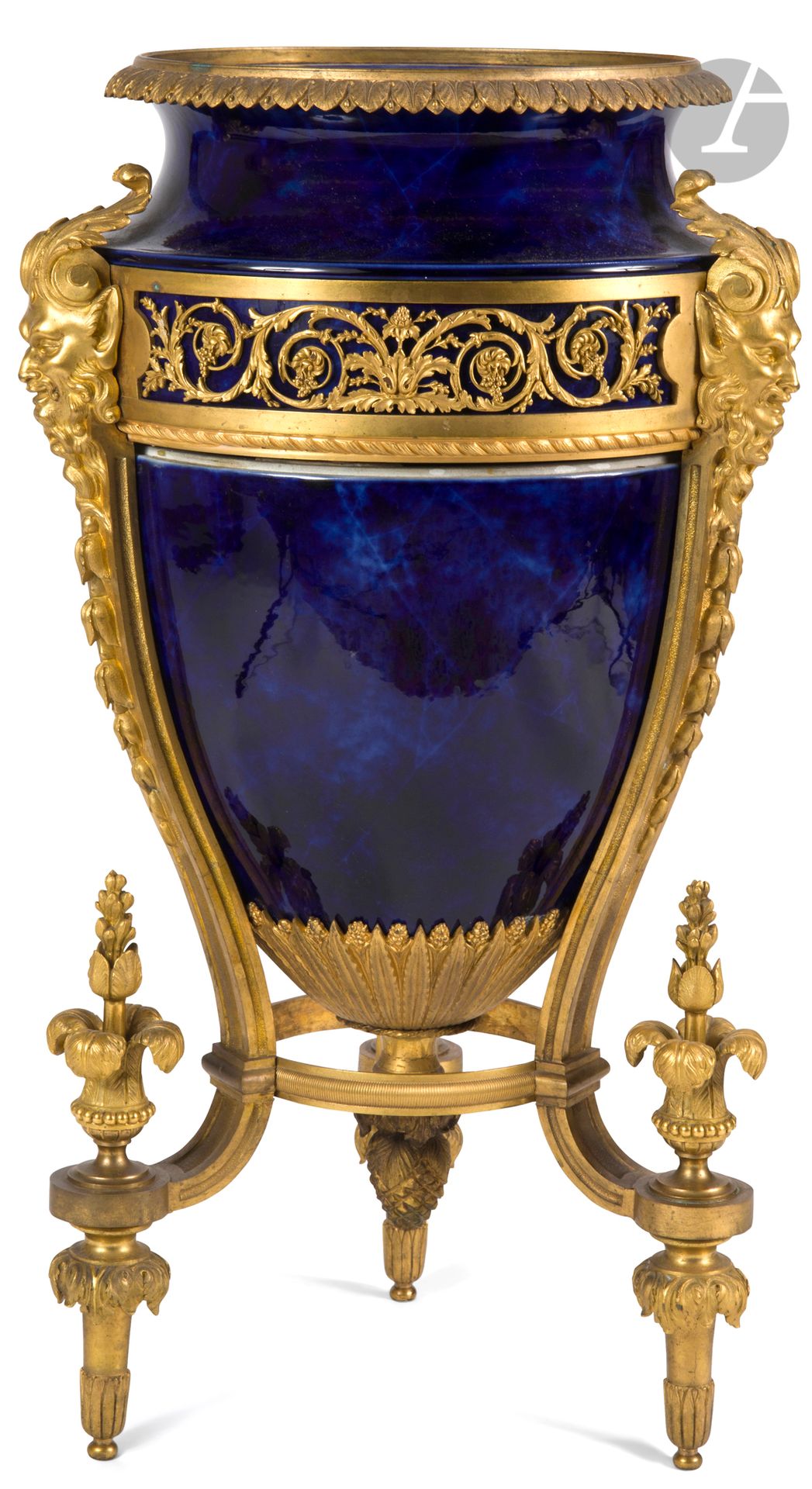 Vase d’ornement formant jardinière en porcelaine de Sèvres, en forme d’amphore, à monture de bronze doré à trois montants à décor de têtes de satyre, entrelacs et plumets ; doublure en zinc ; (peut-être avec un couvercle à l’origine).
Seconde moitié du XIXe siècle.
H : 63 cm