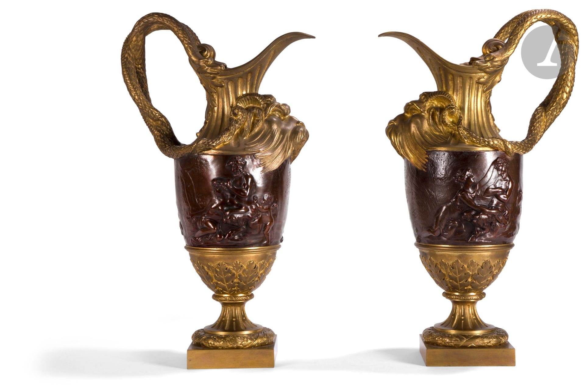 Paire d’aiguières d’ornement en bronze patiné et bronze doré, à décor de serpents, monstres marins et bacchanales, reposant sur un piédouche feuillagé.
D’après un modèle de Clodion.
Style Louis XVI.
H : 48 cm