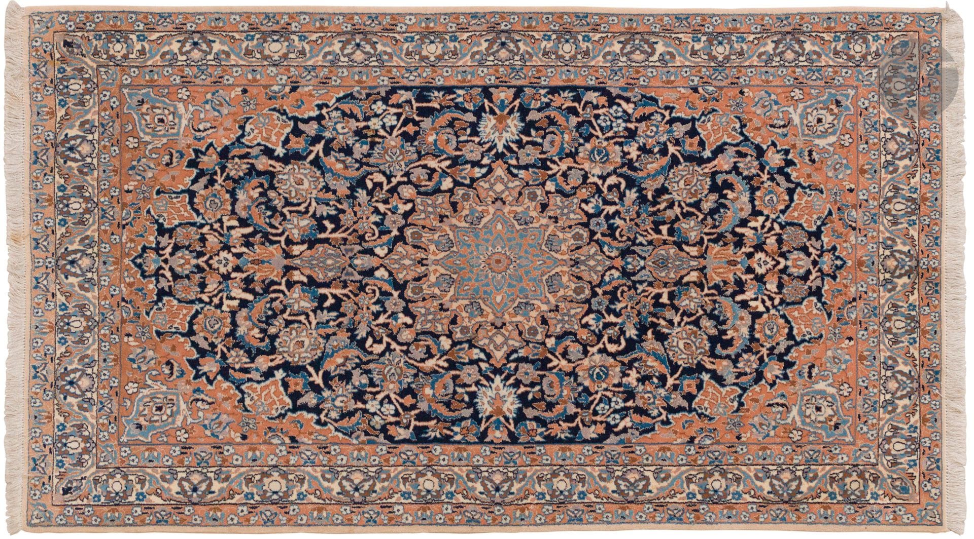 NAÏN, XXe siècle, velours laine, chaînes et trames coton.
Tapis en laine orné d’une rosace centrale sur un fond bleu marine à rinceaux fleuris, bordure ivoire à guirlandes de fleurs. 
117 x 197 cm