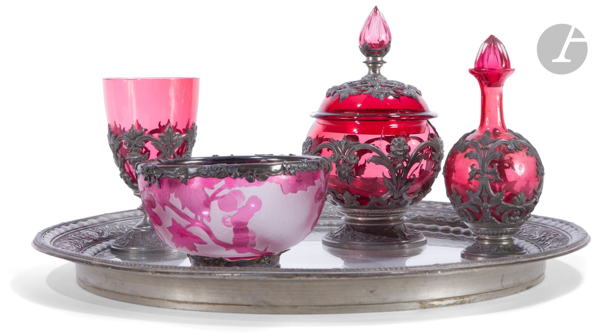Stemmed glass, sugar bowl and bottle in red glass with pewter mount molded with plant motifs (broken sugar bowl and stopper of the bottle without sleeve). 
End of the 19th and beginning of the 20th century 
Glass: H 13 cm; sugar bowl: H: 18 cm
One joined : 
Red lined glass bowl with grape cluster decoration engraved with acid. White metal frame with vegetal decoration.
End of the 19th and beginning of the 20th century.
Bottle : H : 15,3 cm, cup : H : 7,7 cm