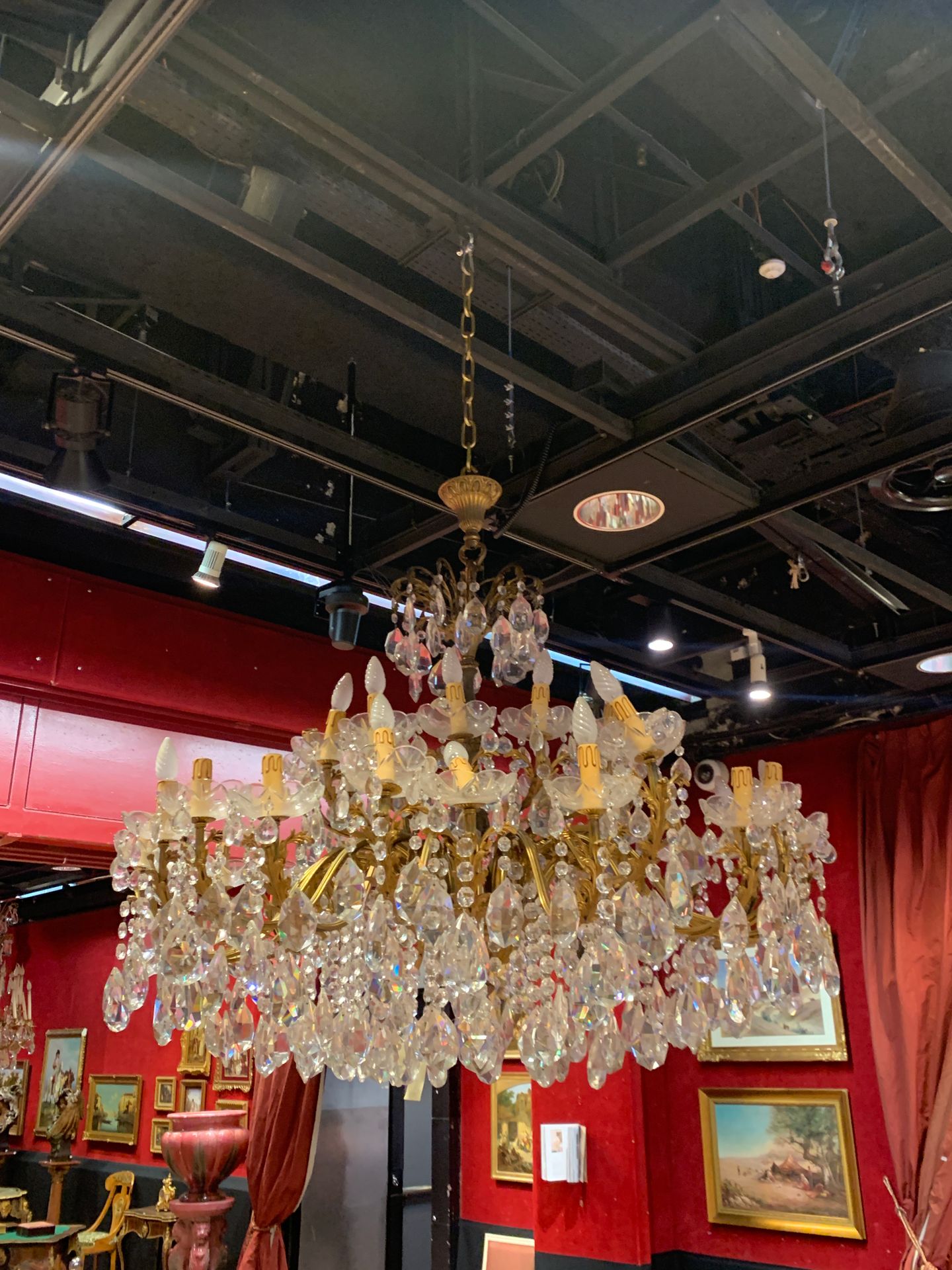 Grand lustre circulaire en bronze doré et verre taillé, à trente-six lumières et décor de cabochons et pendeloques ; (monté à l’électricité).
Style du XVIIIe siècle.
L : 130 cm