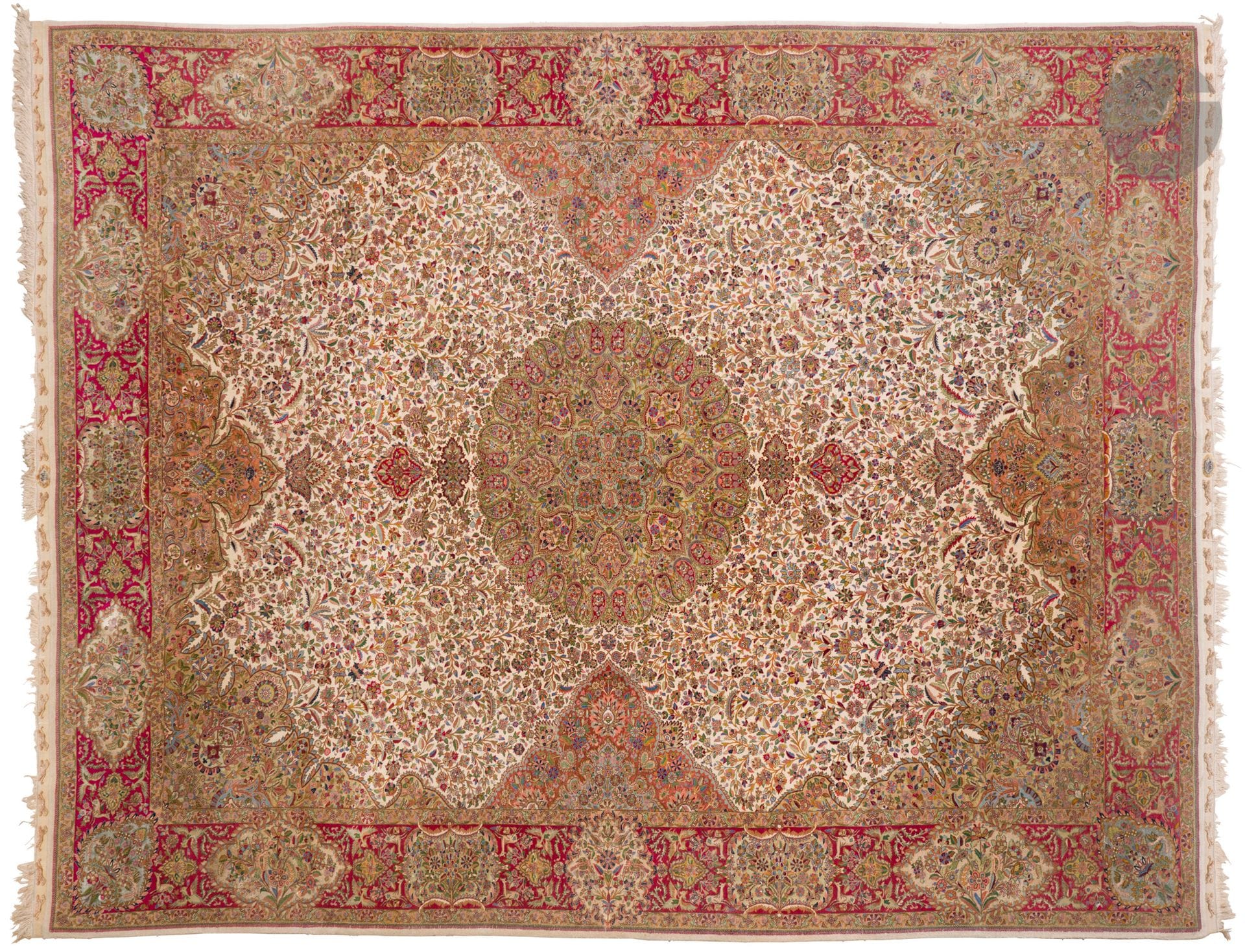 TEBRIZ, XXe siècle, velours laine et soie (15%), trames et chaînes de coton.
Tapis à décor d’un important médaillon central entouré de botehs sur un fond ivoire à bouquets de fleurs, importante bordure rubis décorée d’animaux et de volatiles ainsi que de cartouches décorées de vases fleuris et de volatiles. 
369 x 447 cm
Décoloré par le soleil.