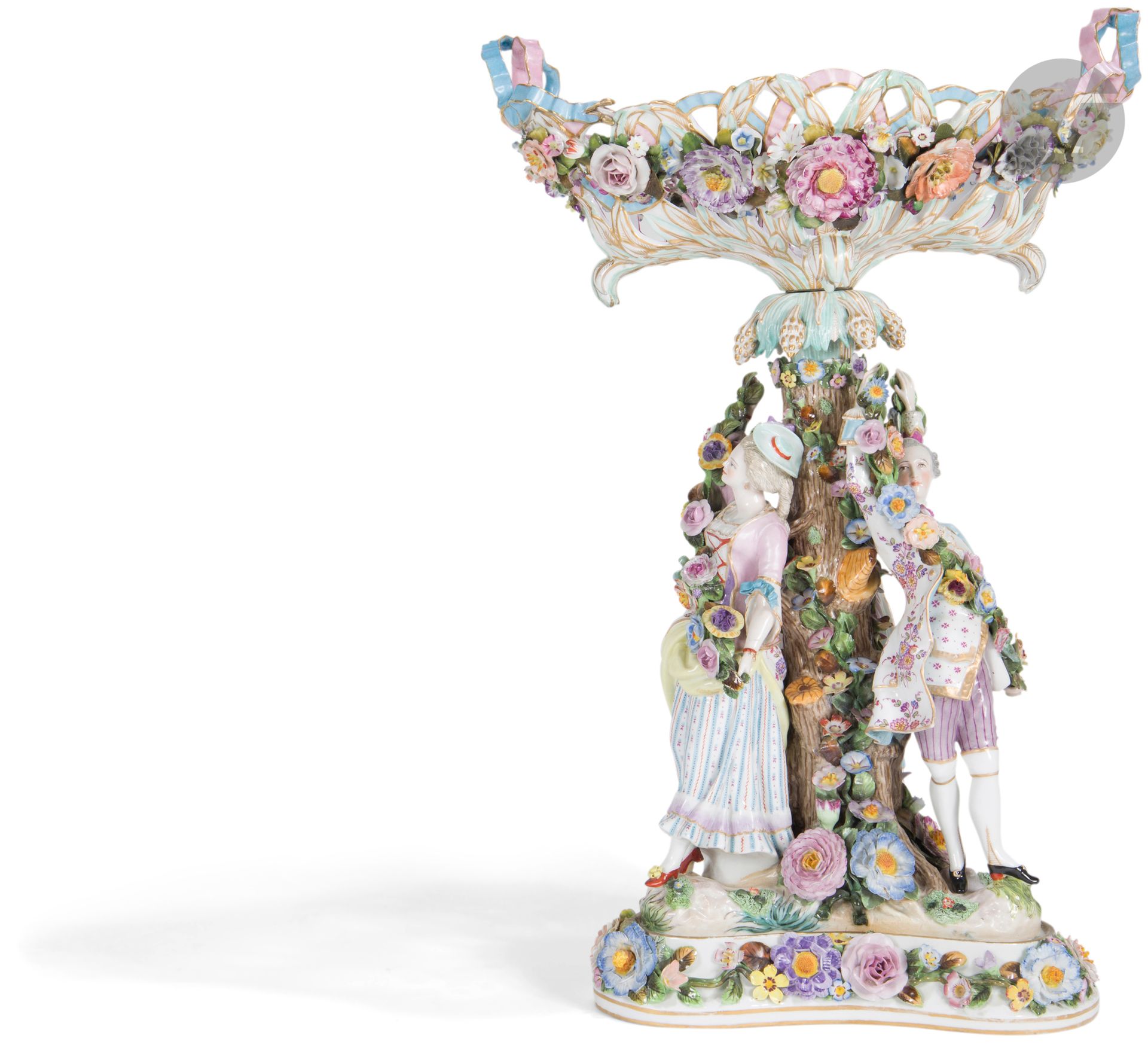 Allemagne
Grand surtout en porcelaine dans le style de Meissen formé d’une corbeille ovale ajourée reposant sur un palmier entouré de trois figures portant des guirlandes de fleurs sur une base triangulaire, à décor polychrome et or.
Fin du XIXe siècle. 
H : 74 cm
Quelques éclats.