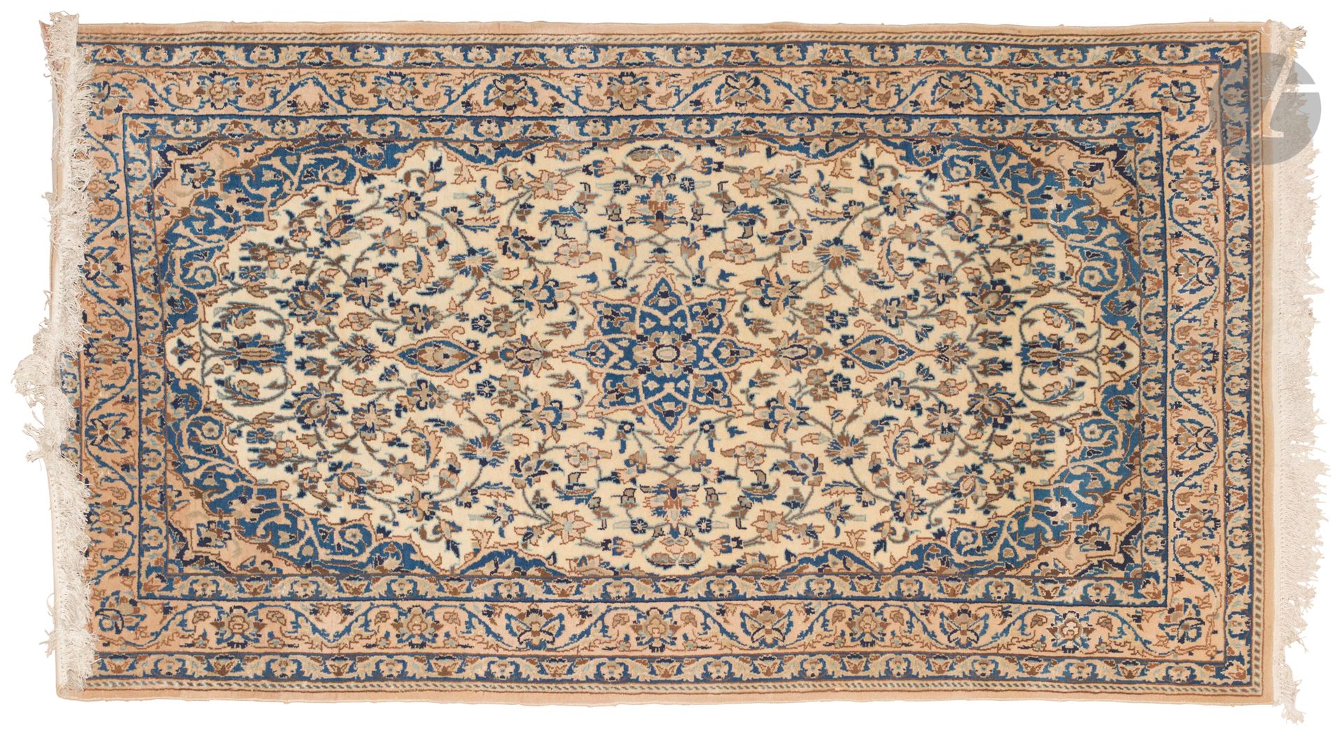 NAIN, XXe siècle, velours laine et soie, chaînes et trames coton.
Tapis à médaillon en étoile bleu sur un fond en ivoire à rinceaux fleuris, bordure à guirlandes de fleurs. 
176 x 94 cm
Taché.