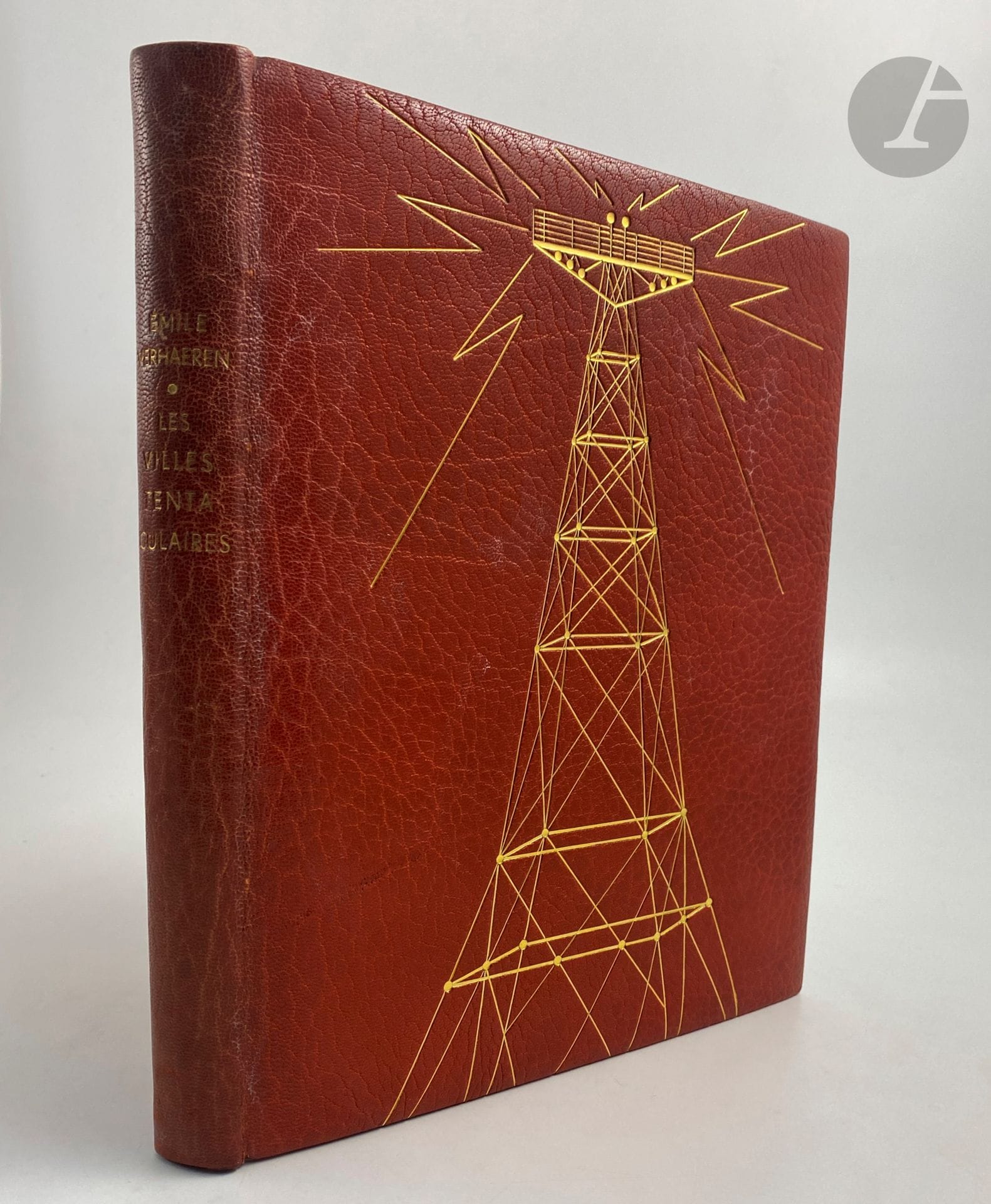 VERHAEREN (Émile).
Les Villes tentaculaires.
Paris : Le Jacquemart, [1950]. — In-4, maroquin fauve, premier plat orné d’une grande antenne radiophonique dorée, second plat orné d’éclairs dorés au centre, dos lisse, intérieur comprenant un encadrement de maroquin fauve orné d’un filet doré, doublures et gardes de papier bois vert, tête dorée, non rogné, couverture et dos conservés, étui (Florence Weingarten).

Édition tirée à 125 exemplaires, illustrée de gravures sur bois en noir et en couleurs dans le texte et à pleine page, de Paul BAUDIER.

Un des 75 exemplaires sur papier vélin de Rives réimposés sur format in-4 carré.

Belle reliure réalisée par Florence Weingarten.

Dos passé. Le premier cahier est légèrement dérelié. Deux feuillets blancs ont été ajoutés, le premier après le faux titre et le second après le titre.