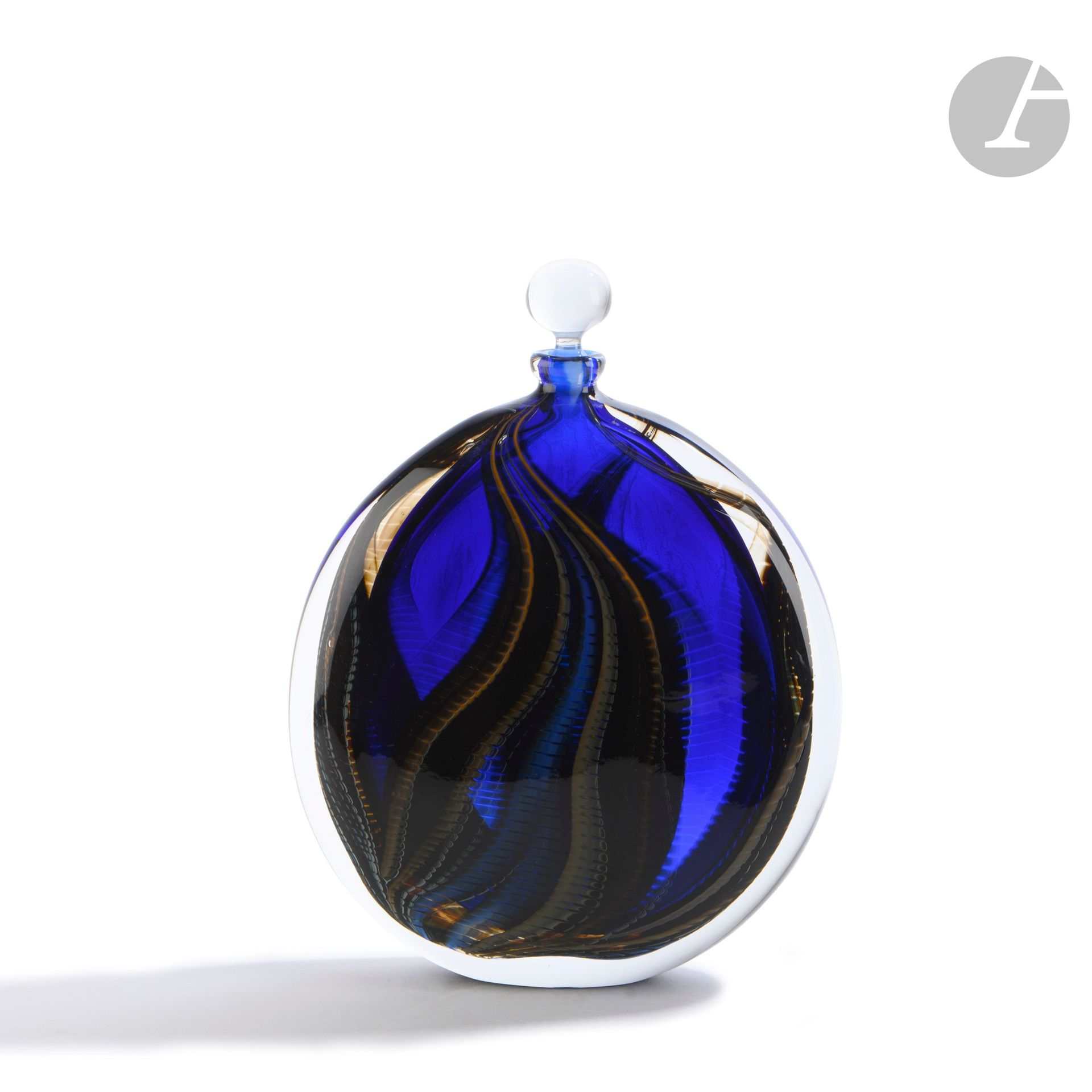 Hervé RASPAIL (France, born in 1960)
Blown glass vase of circular flattened form, with squared decoration of yellow and orange flames on blue bottom. Signed, dated (19)89, located in Allex and numbered L74 under the base. H. 27 cm - L. 20 cm - D. 5 cm