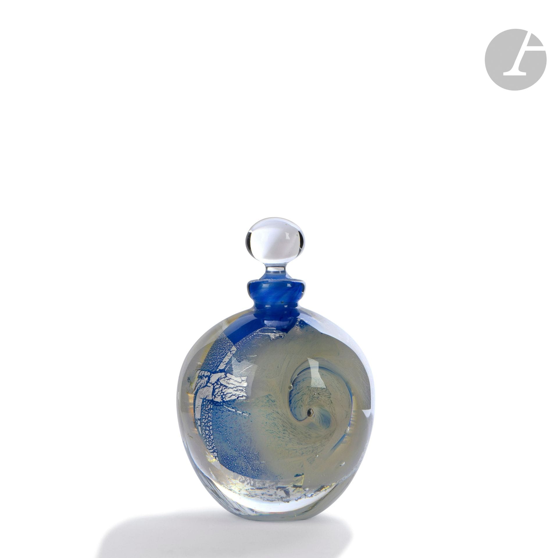 Éric LAURENT (France, 1959-2018)
Flacon boule en verre soufflé à décor de pailles d’argent et d’un cyclone sur fond bleu. Signé, daté (19)88 et situé à Allex sous la base. H. 10 cm – D. 7 cm