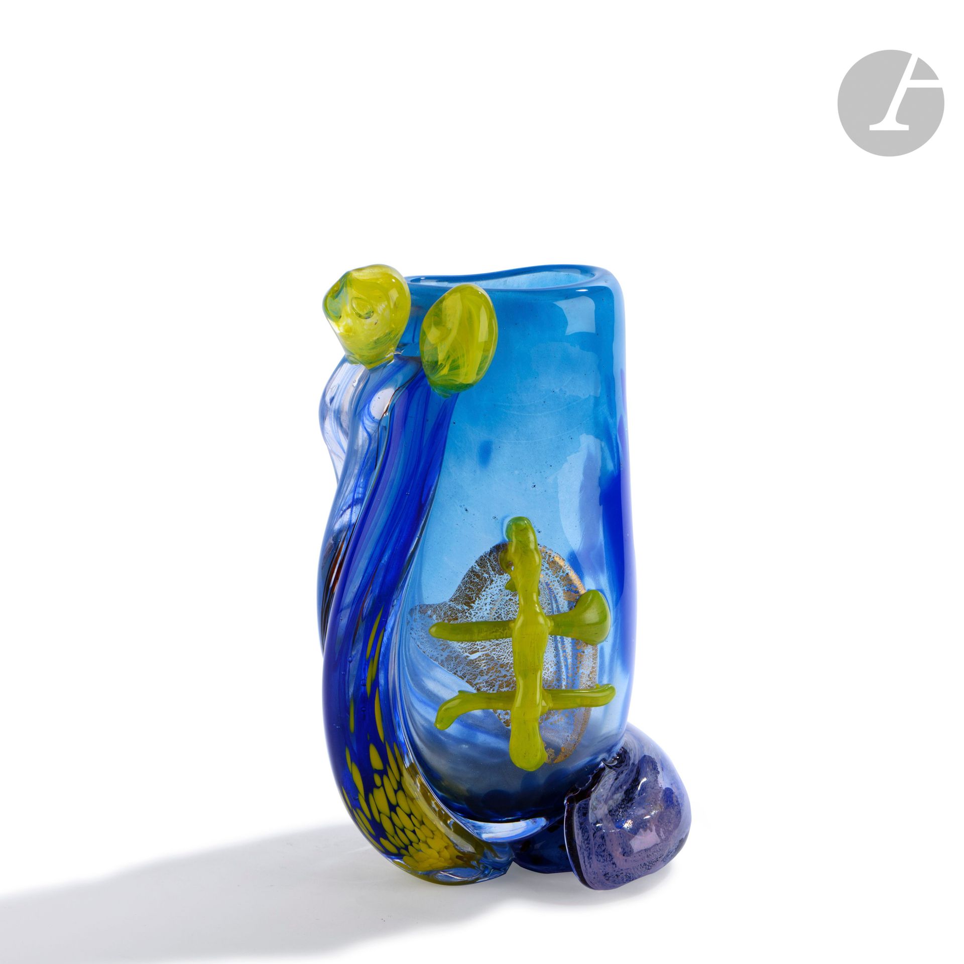René DENIEL (France, born in 1947)
Blown glass vase in blue tones, encircled by a double cord of glass enhanced with yellow beads. Signed, monogrammed, dated (19)92 and noted unique piece under the base. H. 25 cm - W. 14 cm - D. 11 cm