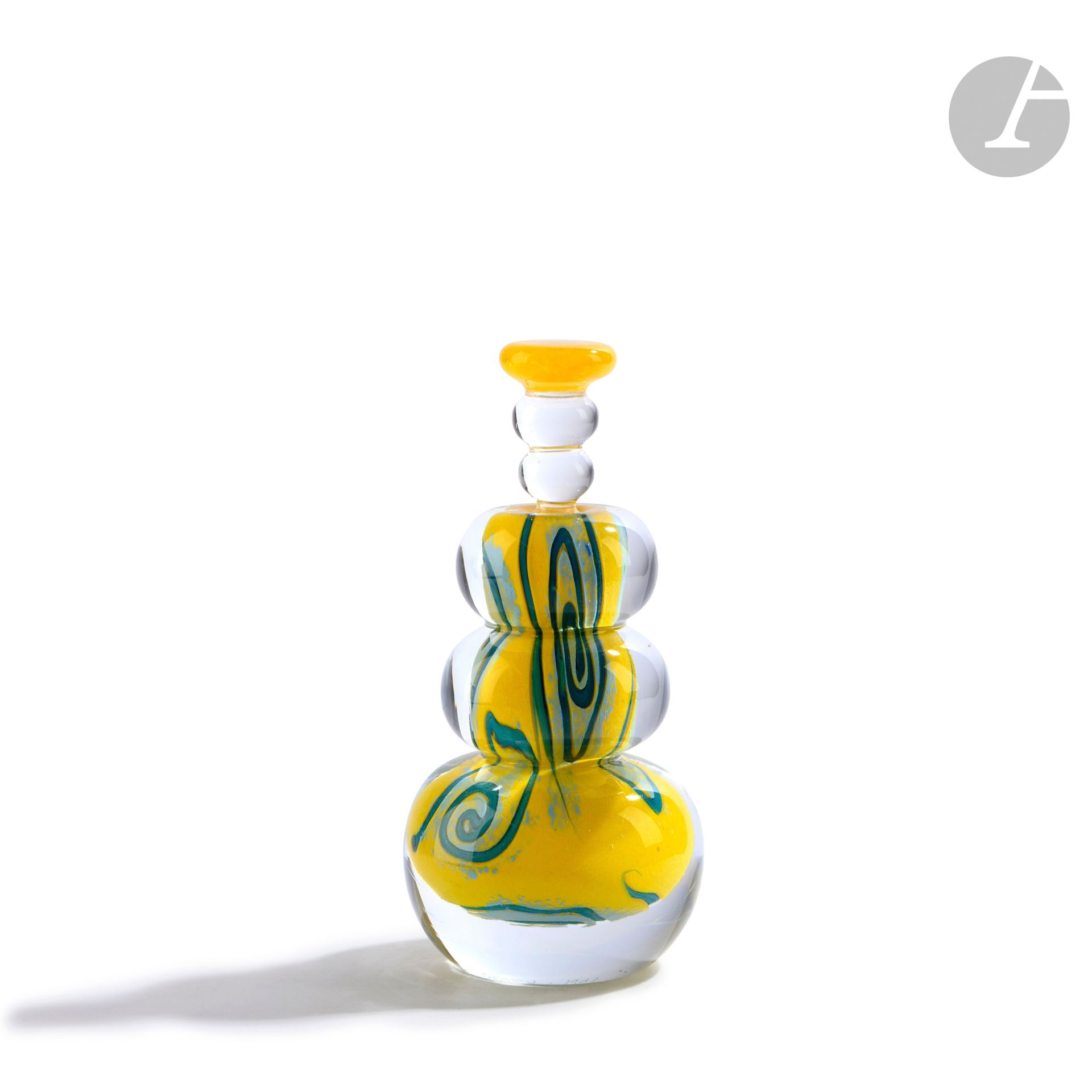 Élisabeth DECOBERT et Francis BÉGOU (France, XXe siècle)
Flacon en verre soufflé en forme d’anneaux, à décor abstrait polychrome sur fond jaune, son bouchon dans le même esprit. Signé et daté 1992 à la base. H. 16 cm – D. 7 cm