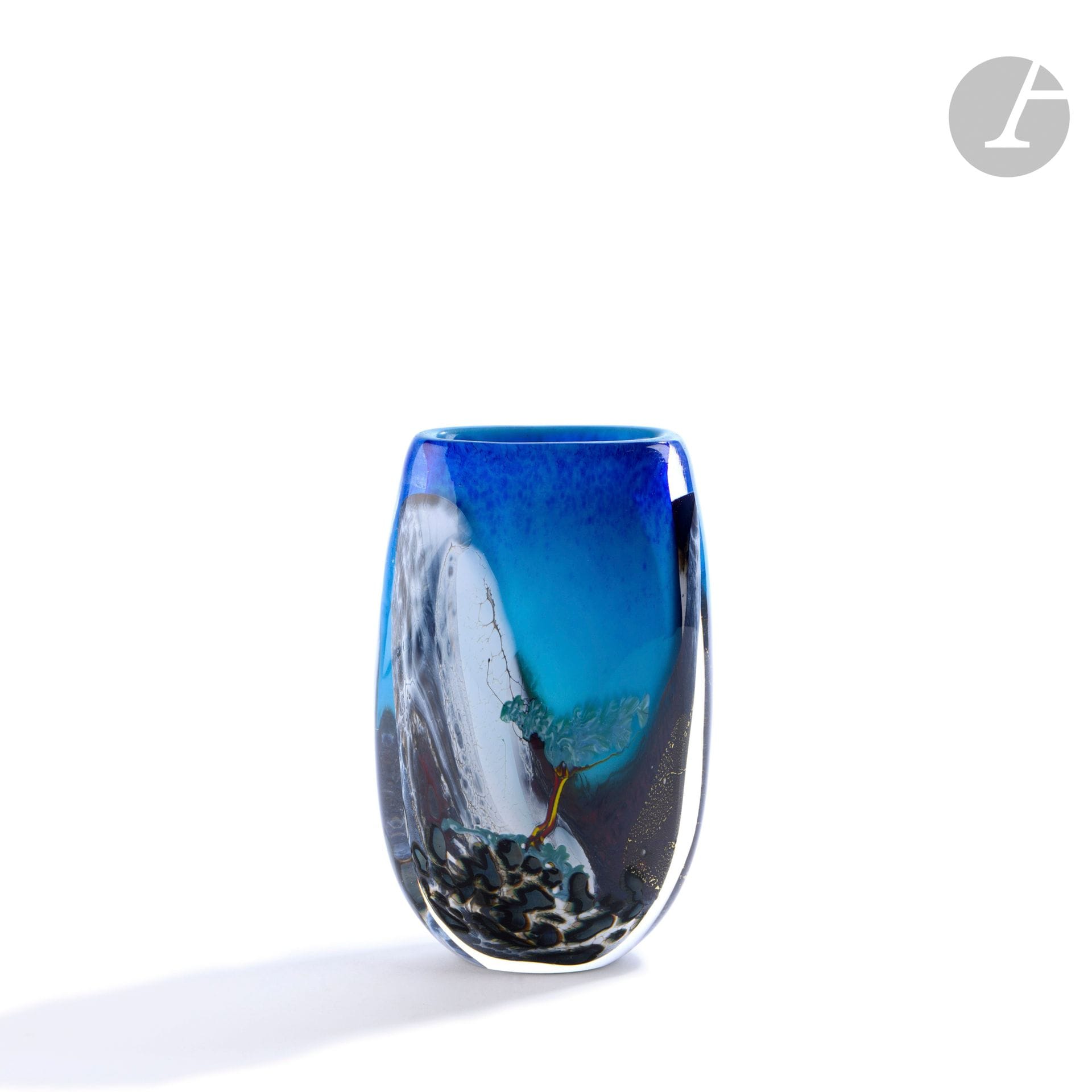 Éric LAURENT (France, 1959-2018)
Vase en verre soufflé à décor d’une cascade et d’un arbre sur fond bleu. Signé E. A (Agnès) Laurent, daté 1992 et numéroté A164 sous la base. H. 18 cm - L. 16 cm - P. 6 cm