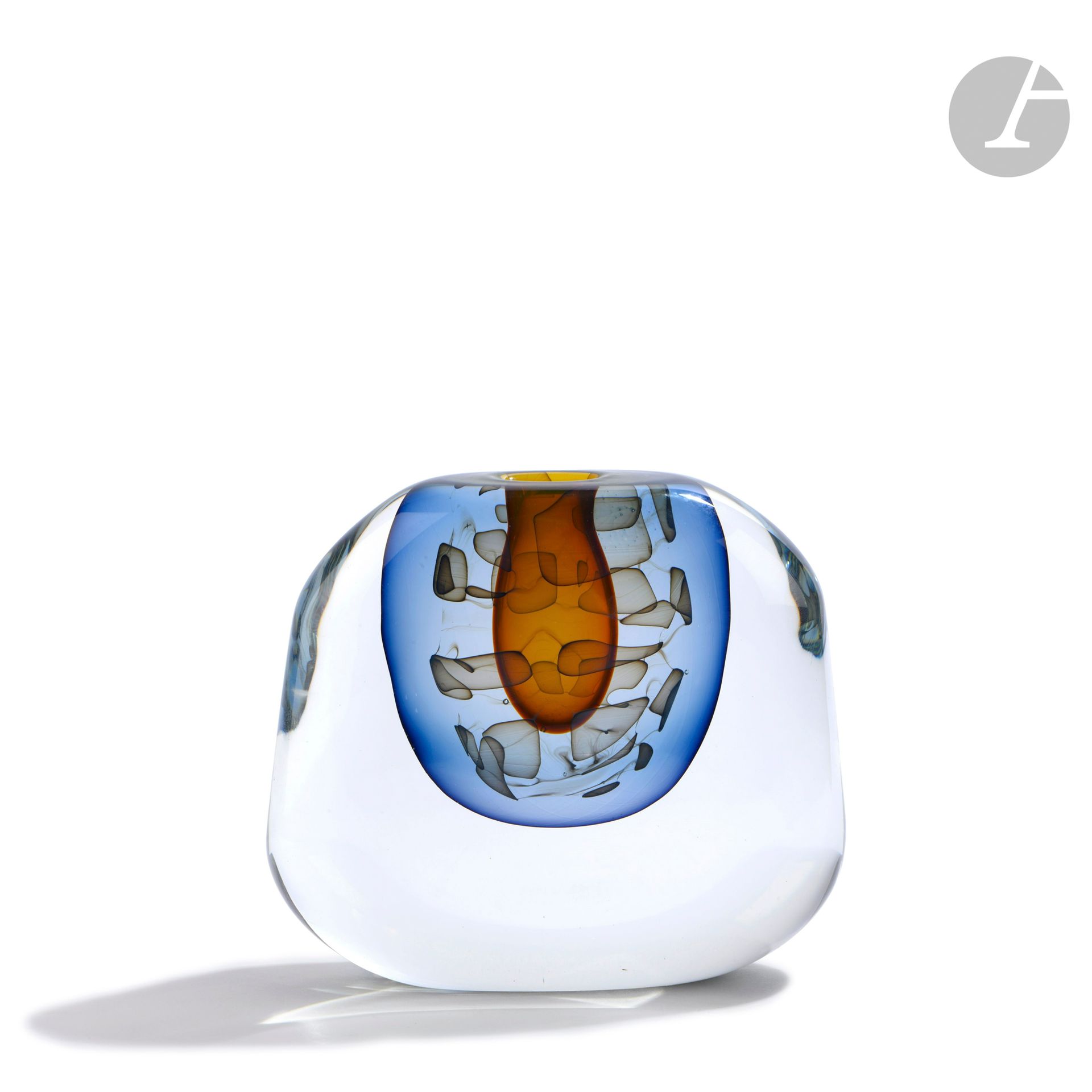 Alain et Marisa BÉGOU (France, nés en 1945 et 1948)
Vase en verre soufflé de forme trapèze à décor de poches orange et bleu et d’un ruban de plaques brunes. Signé et numéroté 11 VII à la base. Pièce réalisée en 1987. H. 13 cm - L. 15 cm - P. 5 cm