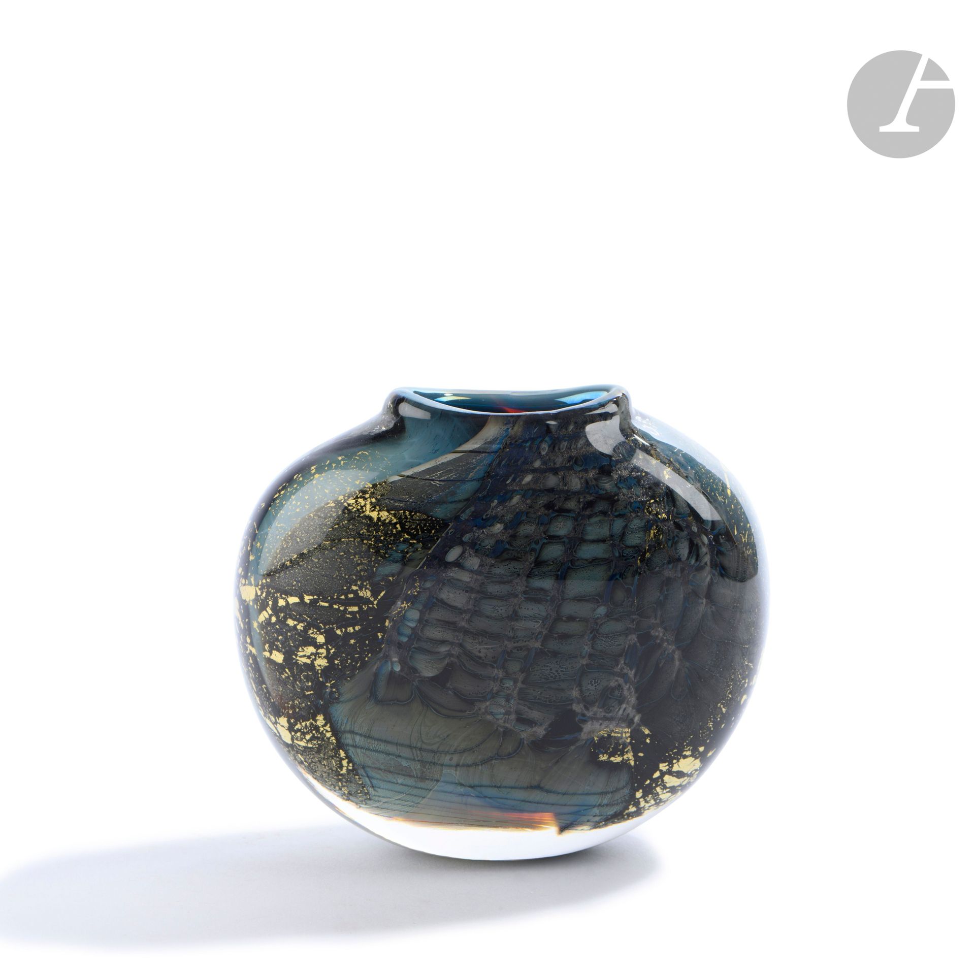 Éric LAURENT (France, 1959-2018)
Blown glass vase decorated with blue mesh and gold straws on a green background. Signed, dated (19)87 and located in Allex under the base. H. 11 cm - L. 12 cm - D. 5 cm