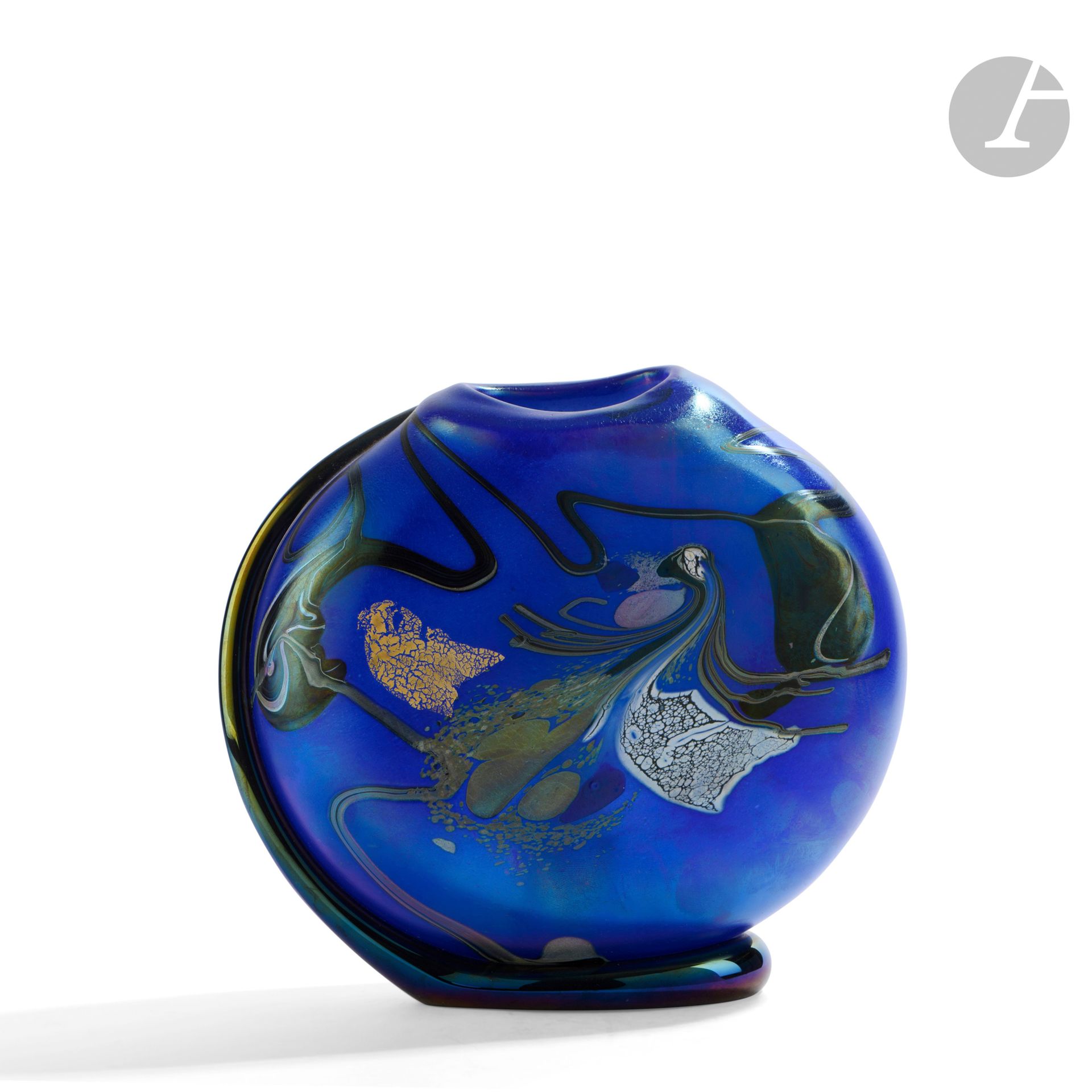 Robert PIERINI (France, born in 1950)
Glass vase blown on a foot in glass cord with polychrome iridescent decoration on a blue background. Signed, dated 1988, numbered BP8 under the base. H. 23 cm - W. 24 cm - D. 9 cm