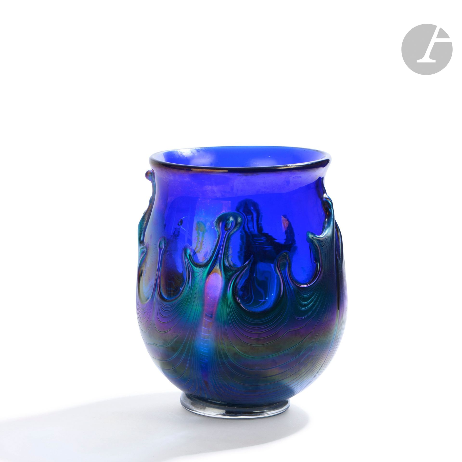 Éric LAURENT (France, 1959-2018)
Vase en verre soufflé bleu sur talon, à décor irisé de spirales et cordons de verre. Signé, daté (19)87 et situé à Allex sous la base. H. 21 cm – D. 17 cm
