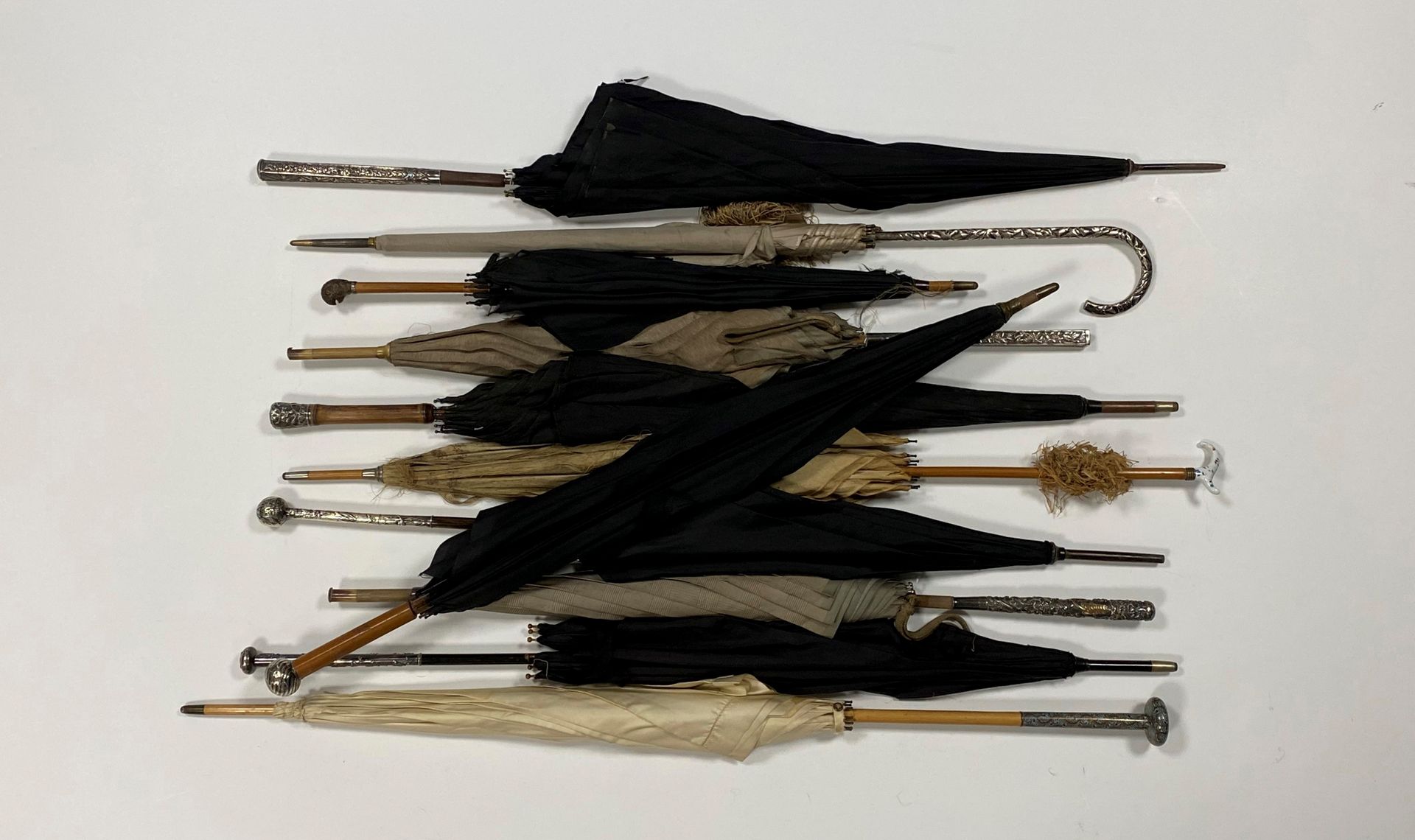 Lot de onze ombrelles ou parapluies, manches métal, porcelaine, bois… (accidents, en l’état)