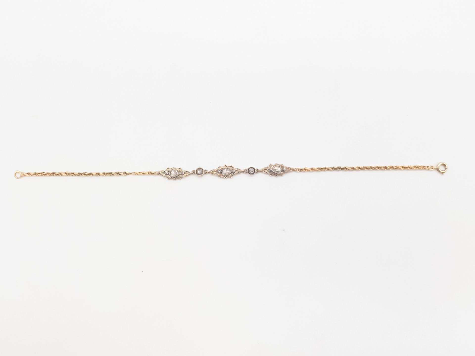 Bracelet en or 14K (585) cordé, agrémenté de 3 motifs ovales sertis de diamants taillés en roses. Longueur : 18,8 cm environ. Poids brut : 3,7 g (chocs, égrisures)