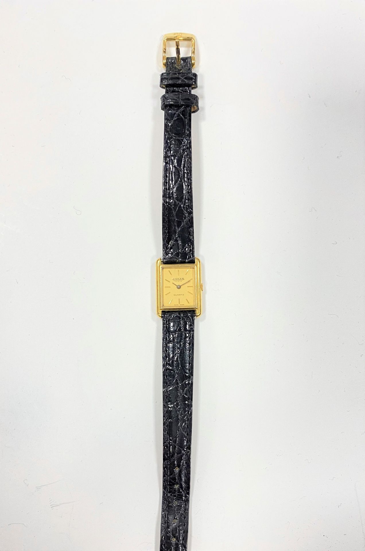 JAEGER LeCOULTRE. Montre bracelet de femme en or 18K (750), mouvement quartz, index bâtons. Bracelet cuir noir.
Poids brut : 16 g