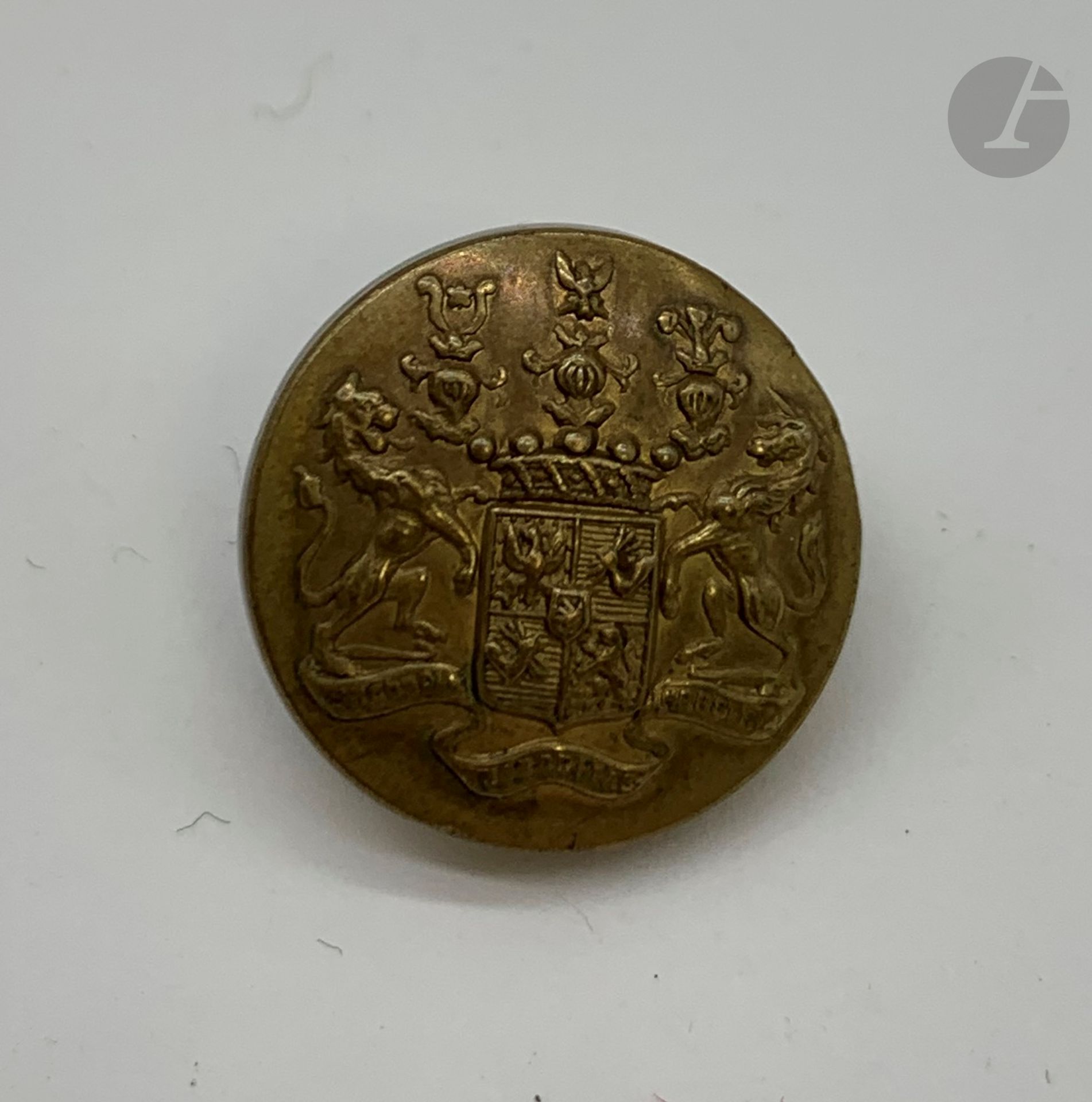 [ROTHSCHILD - VÉNERIE]
Bouton de gilet de livrée aux armoiries des Rothschild.
Marqué au verso «La Belle Jardinière, Paris».
Laiton estampé et doré.
D : 1,7 cm