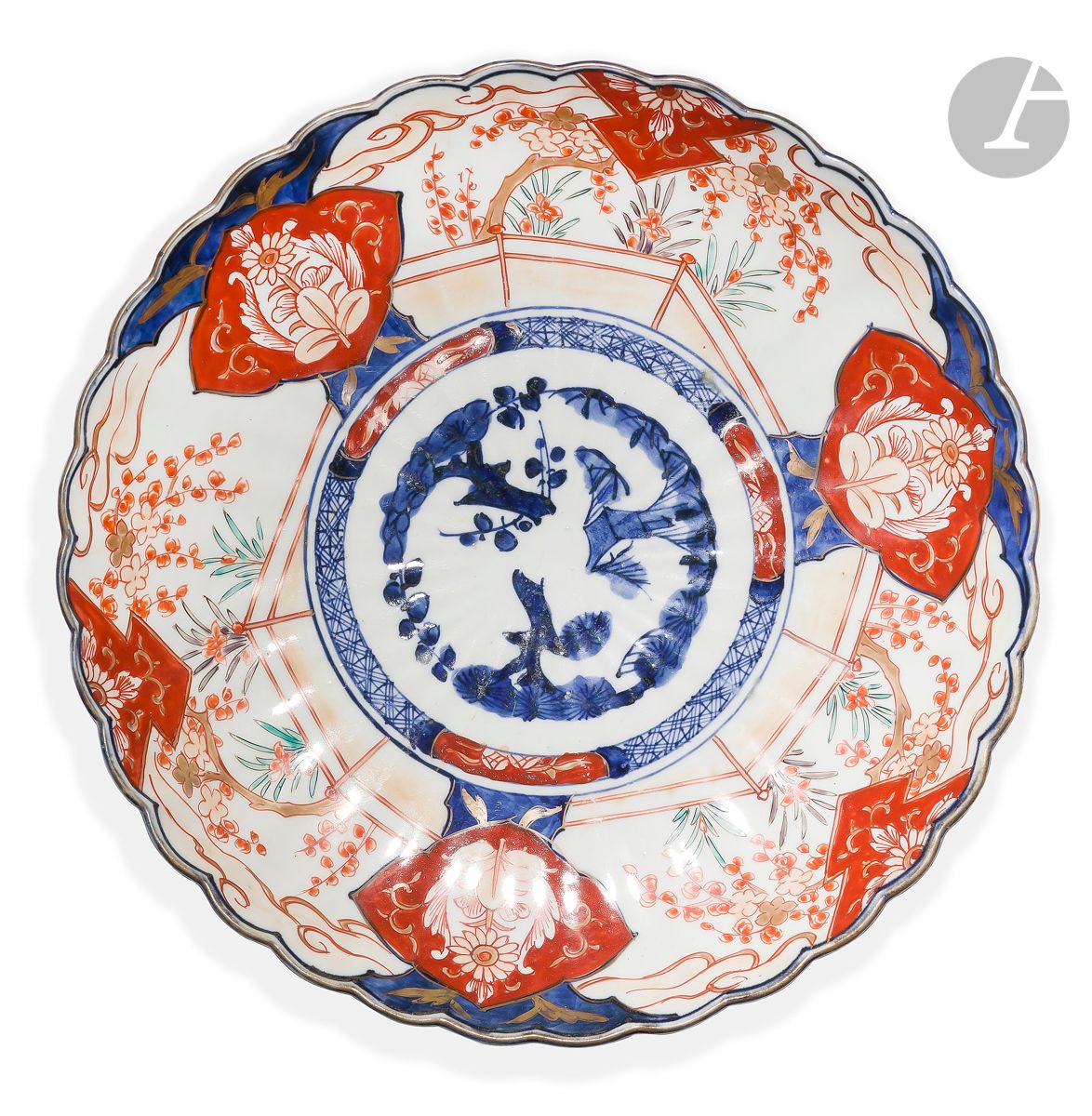 JAPAN
Round cup with scalloped edge in porcelain with Imari decoration (blue, red, green and gold) of floral motifs. Stylized. Gilded thread on the edge. Flowering stems on the reverse. 
End of the 19th century 
D. 30,5 cm