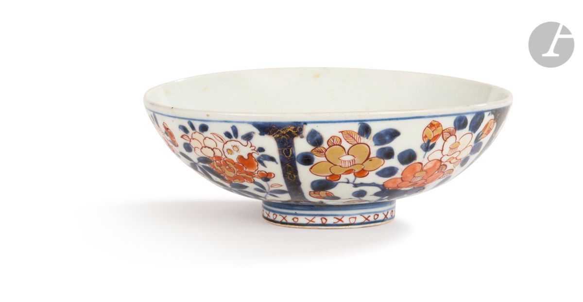 JAPAN
Round porcelain bowl on a heel with blue, red and gold Imari decoration of compartmentalized floral motifs. The interior decorated with a flowering vase on a tripod. On the reverse side a flowering stem.
18th century
D. 19 cm
Small restoration on the heel.