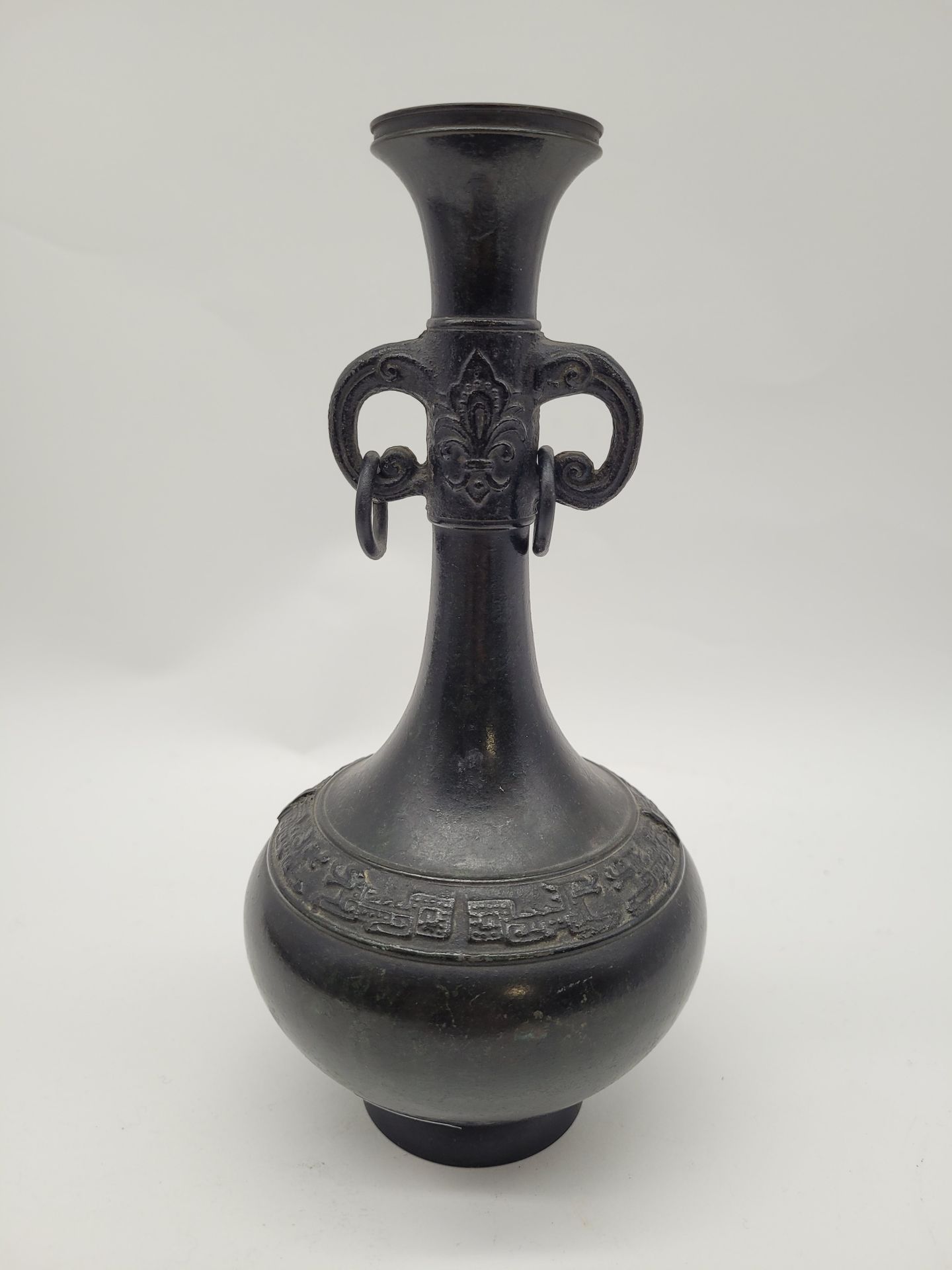 Long necked copper alloy vase, Japan, China style, 19th century 
Body decorated with an archaic frieze, two scroll handles with rings. 
Inscription dedication for a later gift under the base. 
Height : 21 cm
