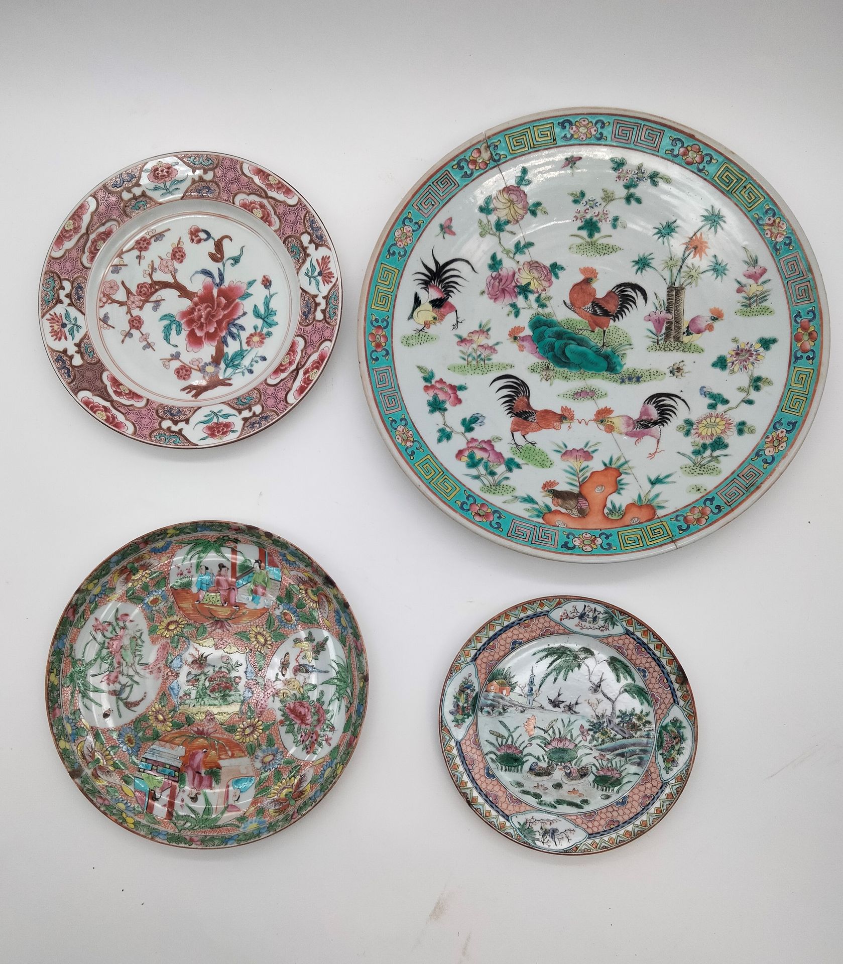 4 porcelain plates, China, 18th - 20th century 
Of which: 
- 1 in Compagnie des Indes porcelain with central peony decoration. Diameter : 23,5 cm 
- 1 in Canton porcelain decorated with medallions of daily scenes. Diameter : 24,2 cm. 
- 1 Canton porcelain of lake landscape, birds, ducks and pagoda. Diameter : 18,5 cm 
- 1 in porcelain with polychrome enamels of five roosters. Diameter : 34,5 cm. Broken and glued 
Accidents and restorations.